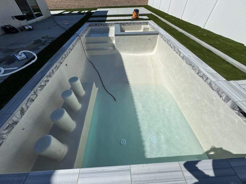Pool and spa modern shape turf around pool by Premier Pools and Spas Temecula