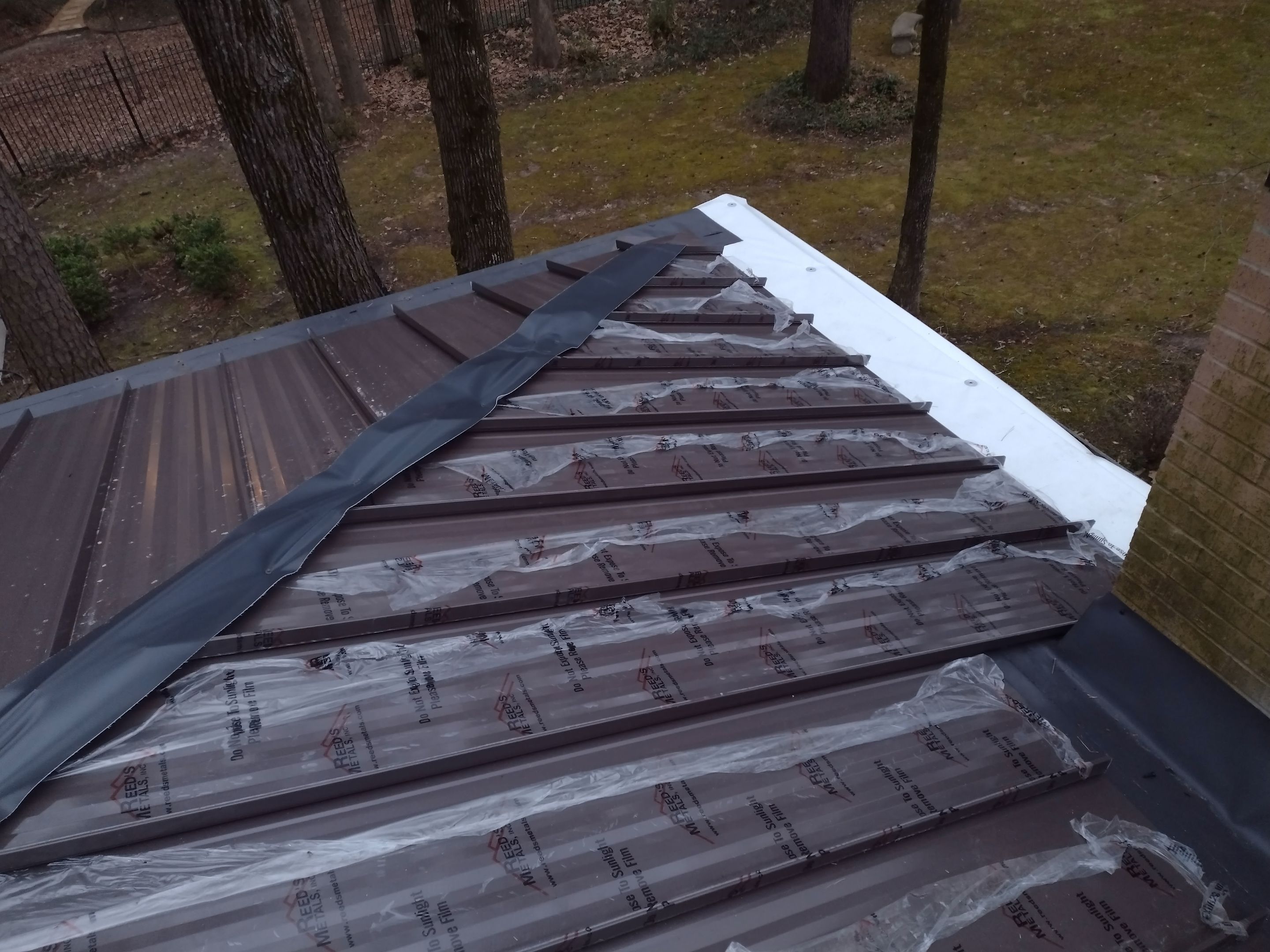 Residential Roofing Installation using PVC membrane and 24 gauge Standing Seam Metal by Hostetler Roofing