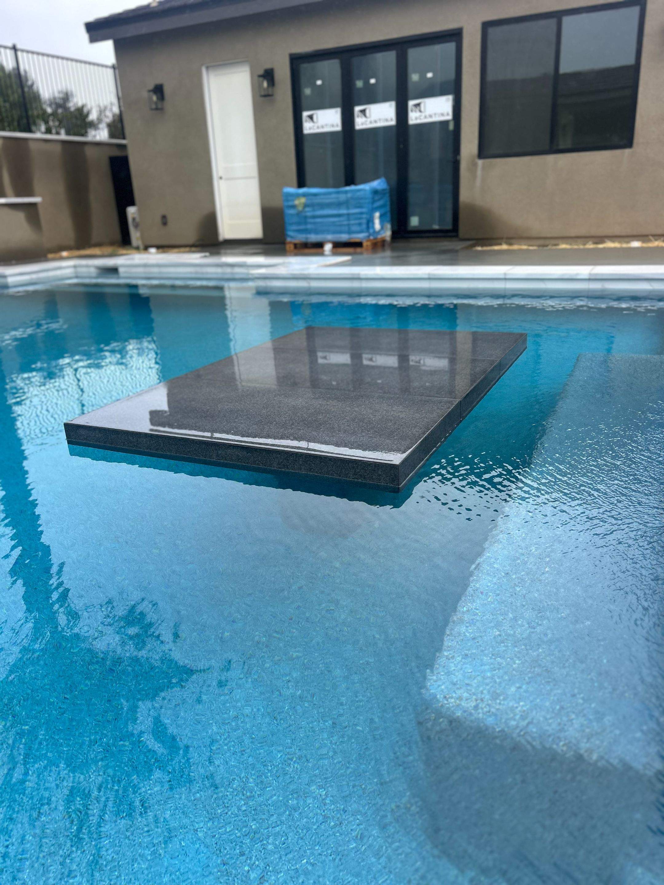 Pool spa zero edge spa, large water wall, floating steps, bar stools by Premier Pools and Spas Temecula