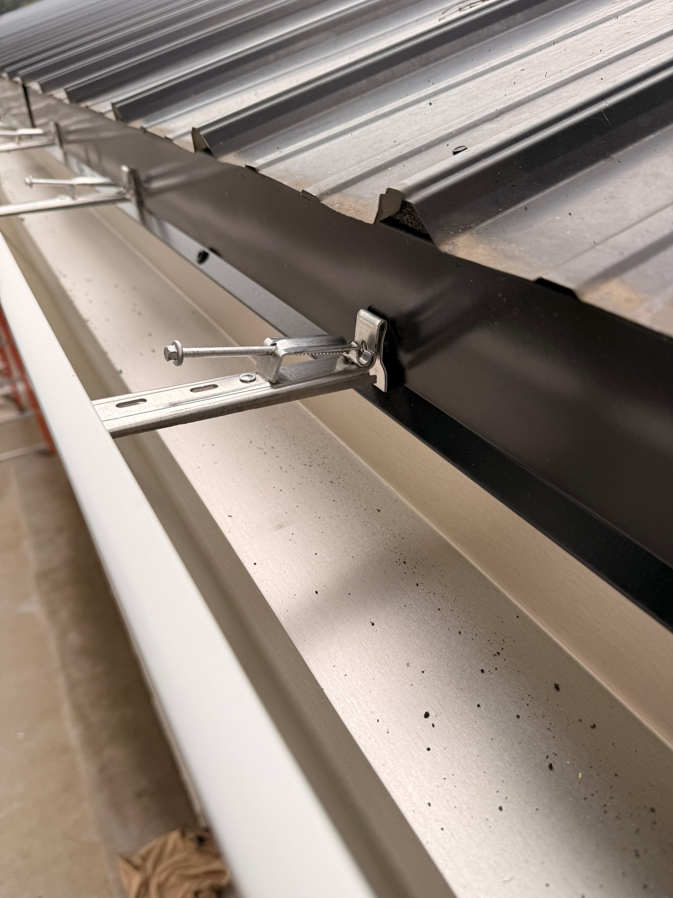 Seamless Gutter and Gutter Helmet Installation on Bellaire Metal Roof by Rainbow Seamless Systems