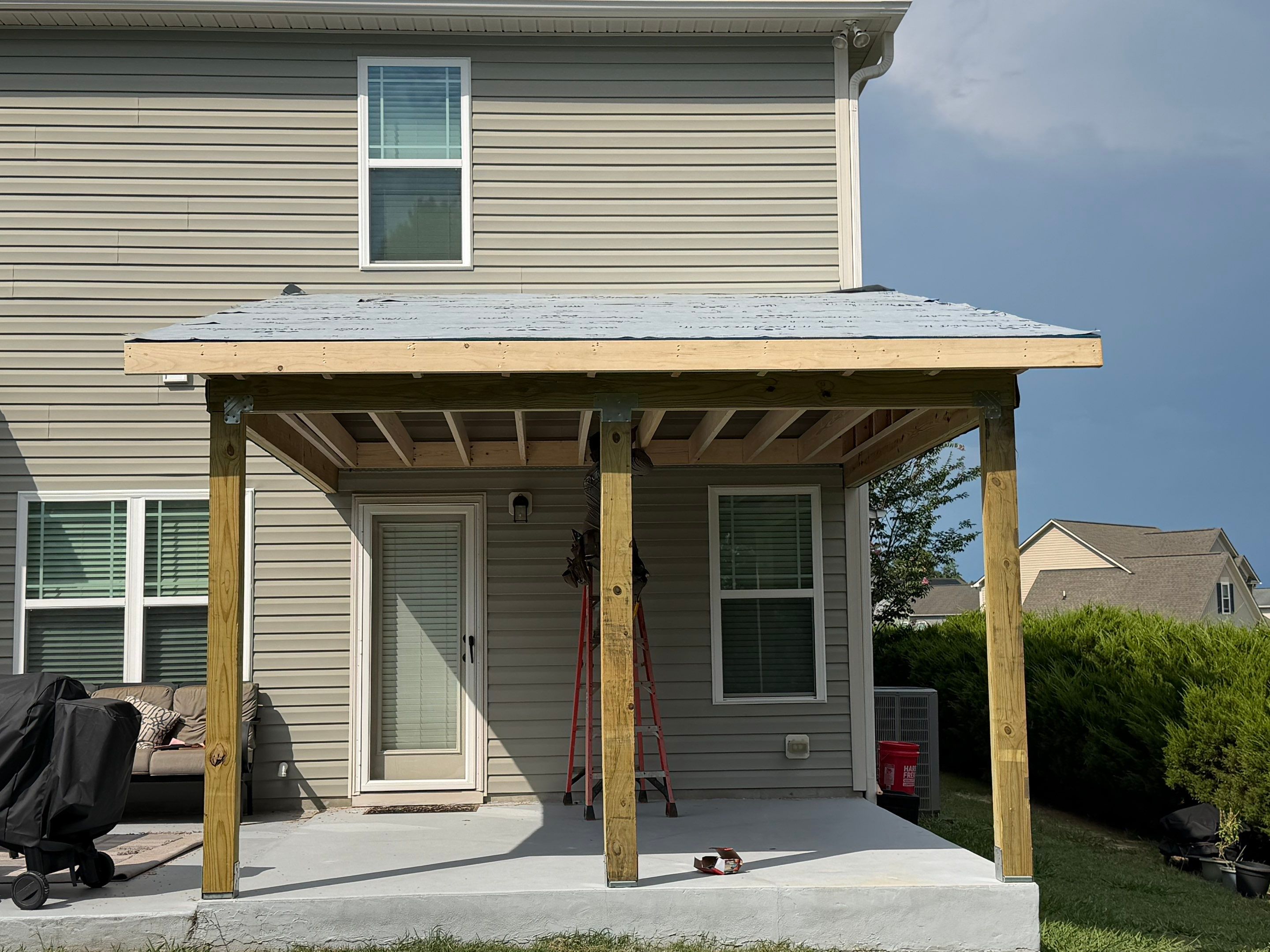 Covered Patio Roof Construction with Architectural Shingles in Garner by The Remodeling Company