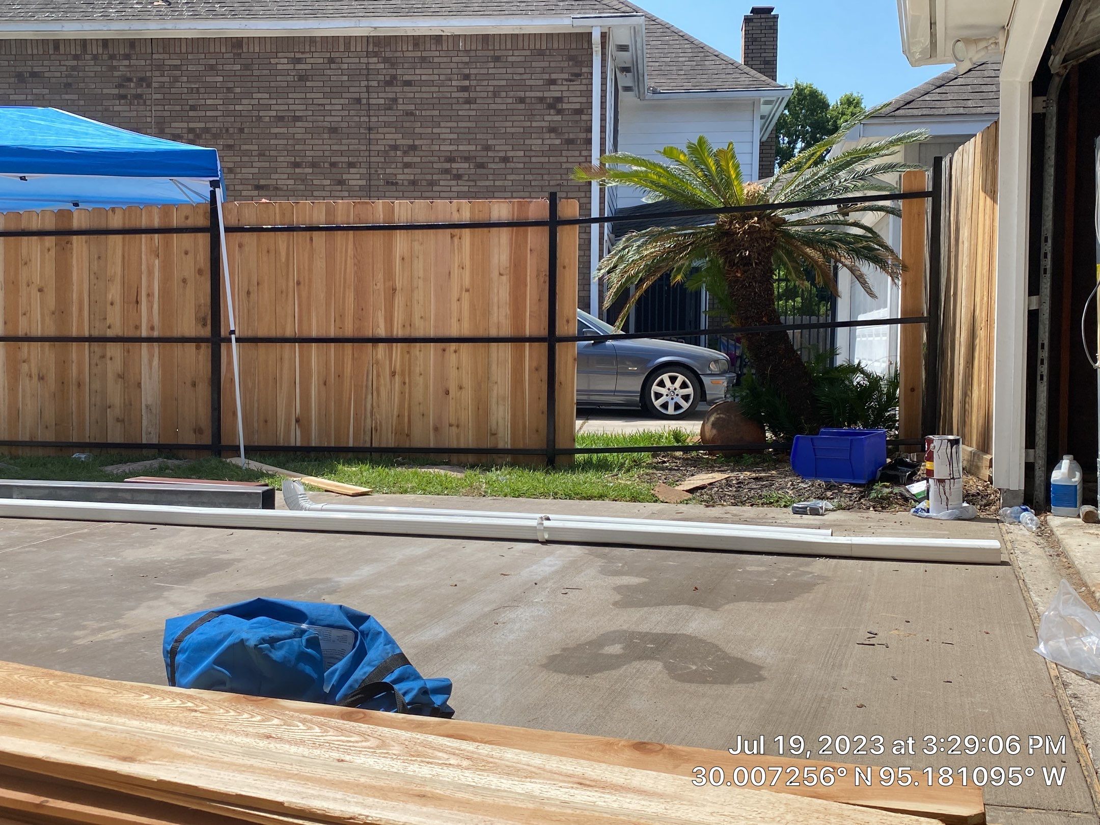 Complete metal driveway gate install with solar powered opener. Metal fence frame with Cedar Pickets by Astro Outdoor Designs 