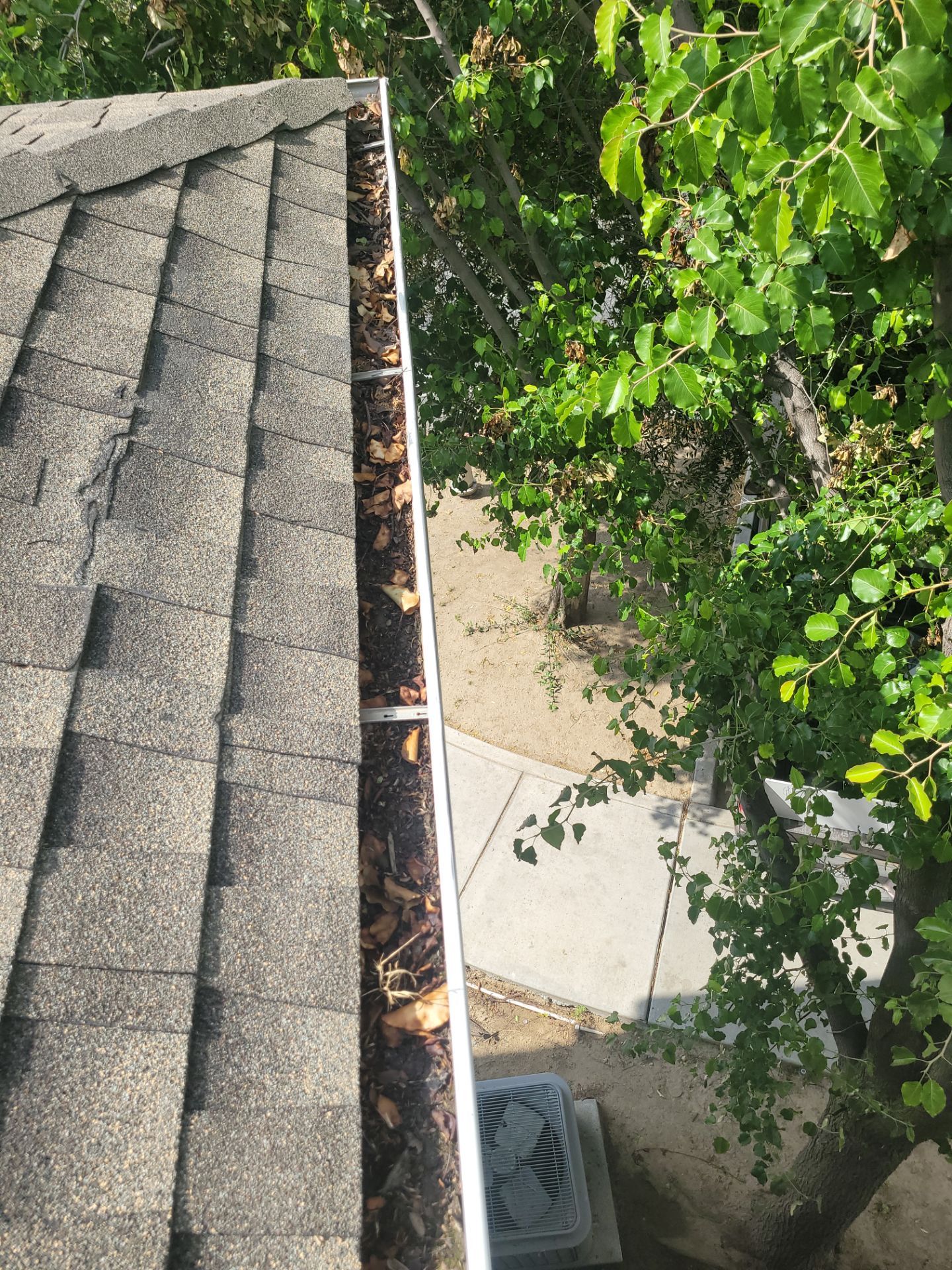 Commercial gutter cleaning Bakersfield, CA before photo with filled gutters