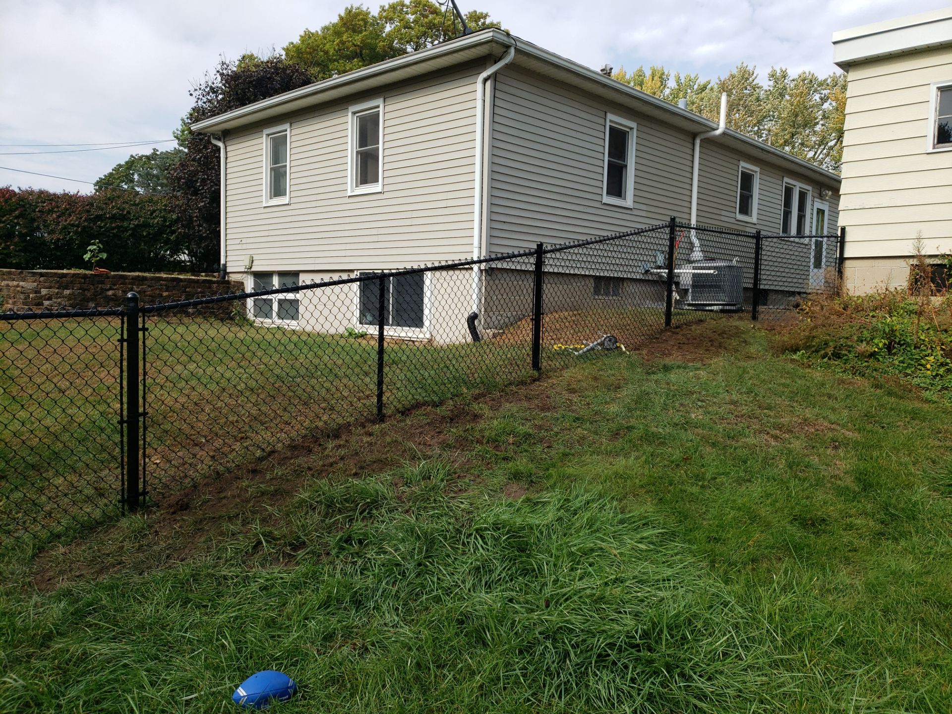 Residential Black Vinyl-Coated Chain Link Fence in Waterloo by Perfect Picket Fence and Stain