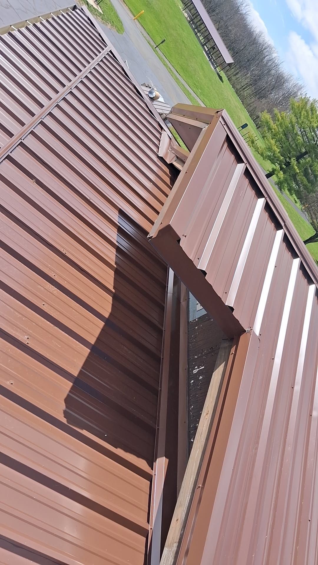 Brown R-Panel metal roof with solar by Atlas Roofing & Restoration