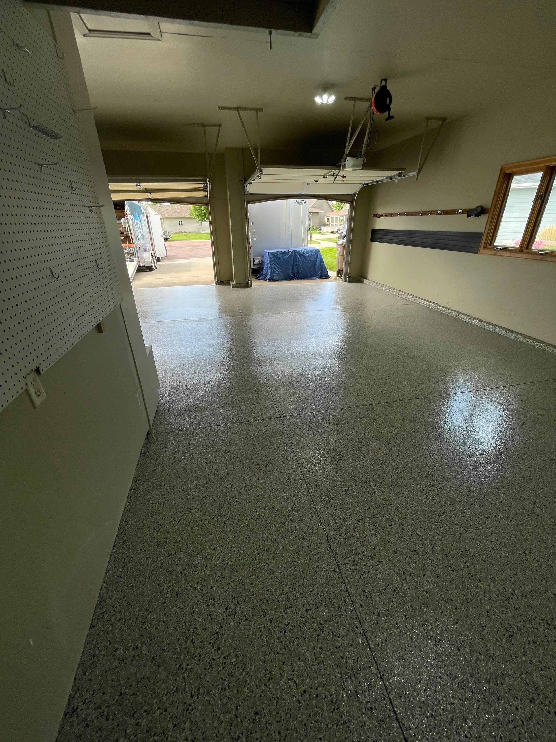 Cabin FEver Flake Garage Floor Coating Installation in Sioux Falls by Select Painting, Coatings & Garage Cabinets