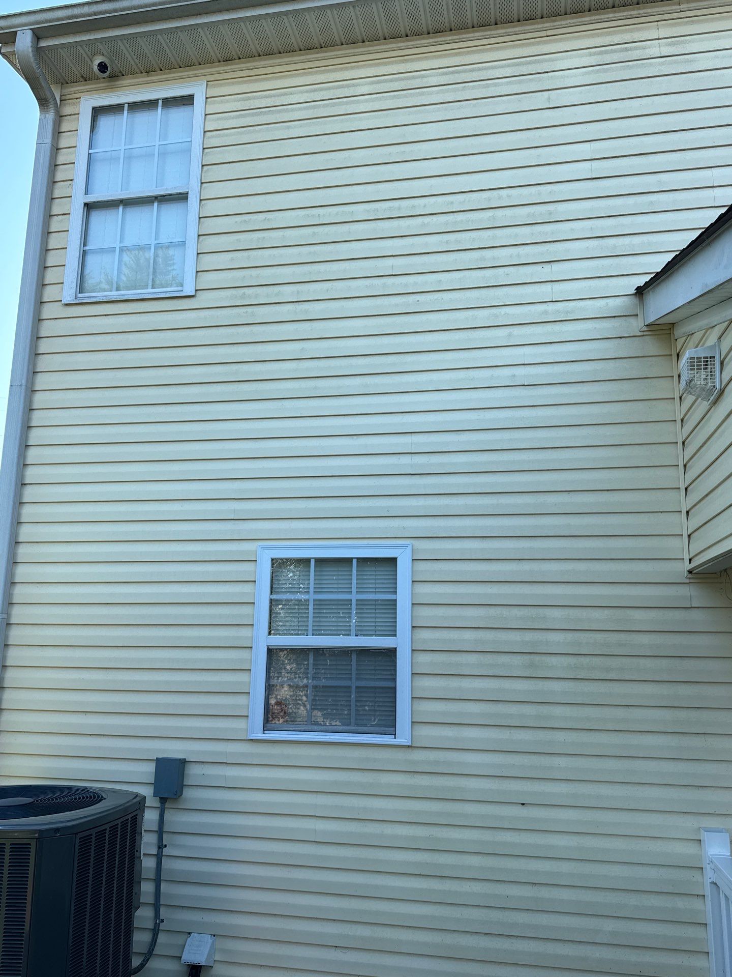 the service being done is cleaning the exterior siding of a house using pressure washing techniques to remove dirt and stains