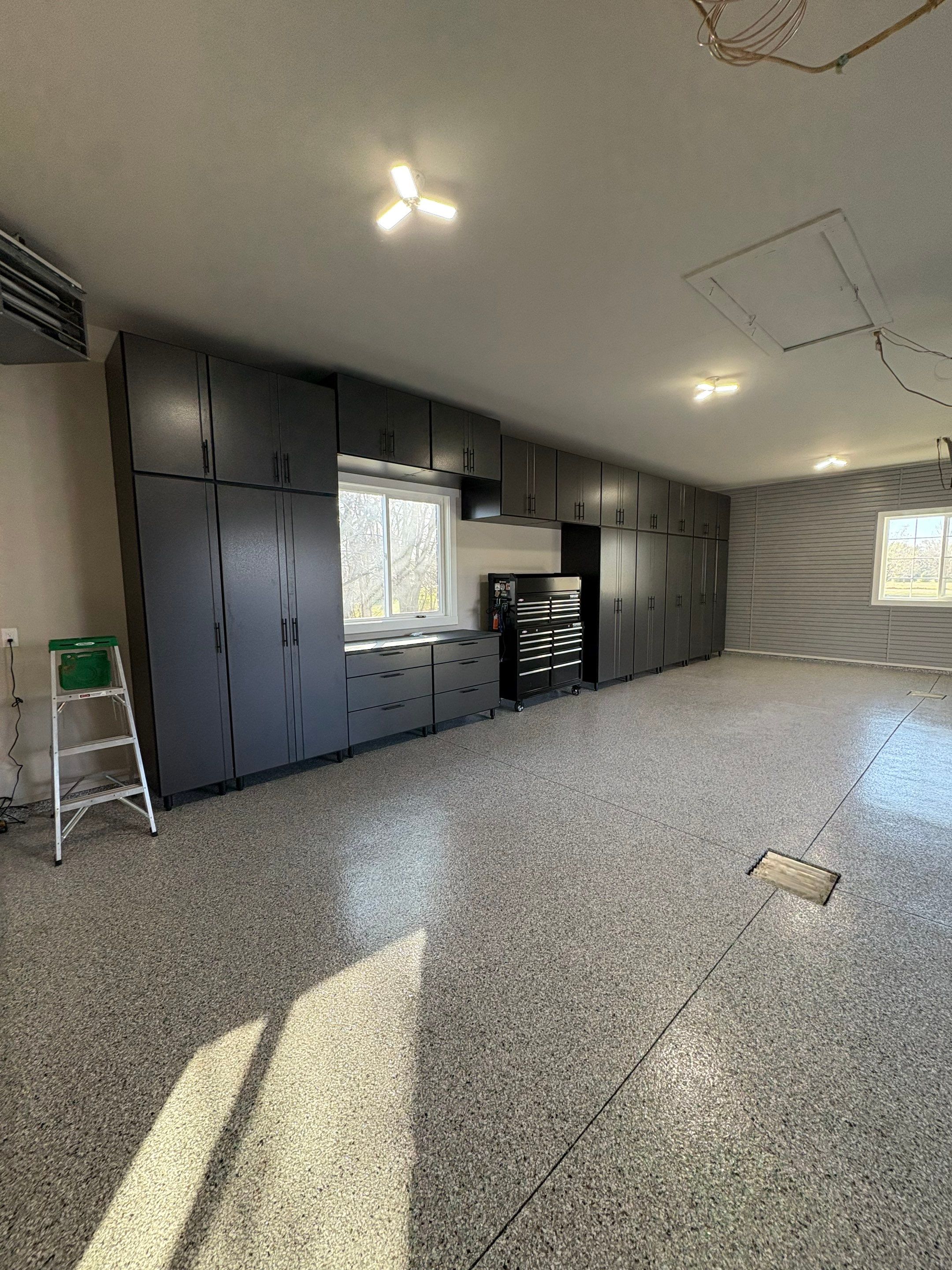 Yankton Garage Transformation with Dark Storage Cabinetry and Epoxy Flooring by Select Painting, Coatings & Garage Cabinets