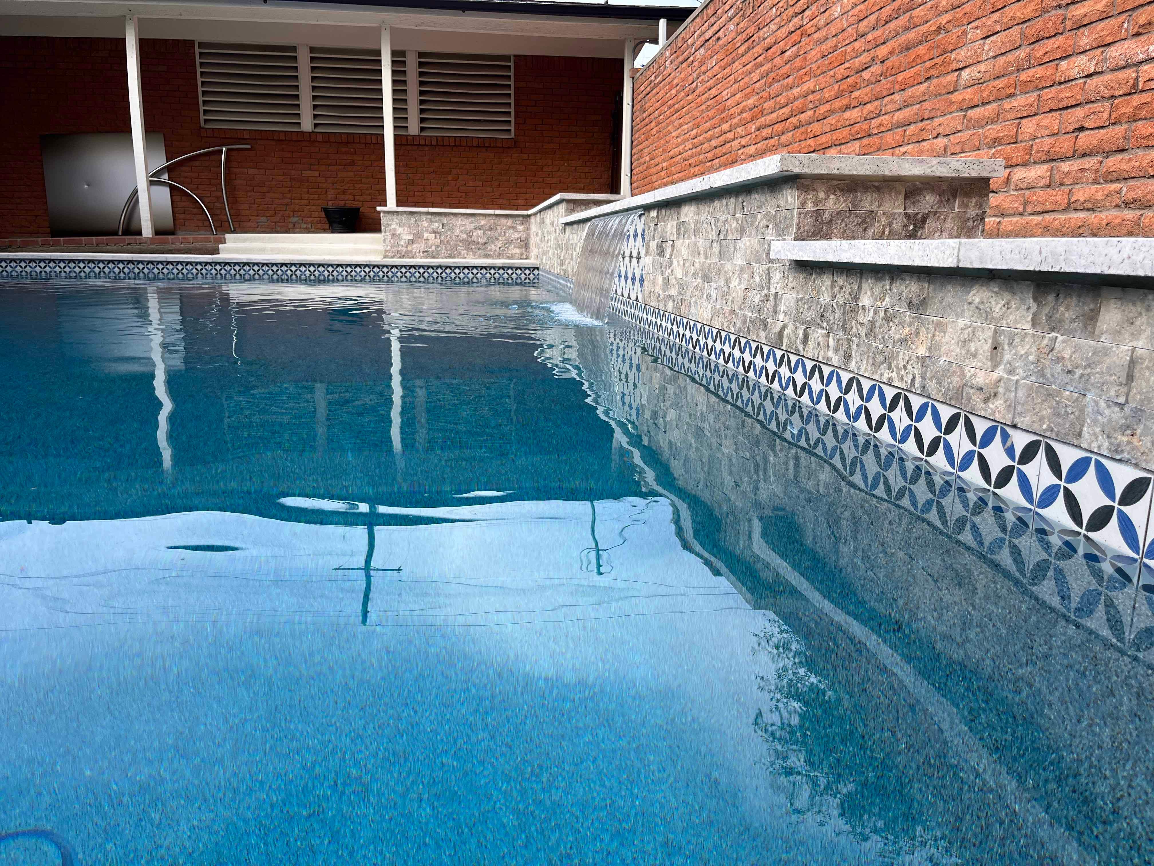 Geometric Pool with Raised Stone Wall and Sheer Descent by Pinnacle Pools and Spas - DFW
