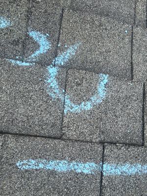 Close up of asphalt shingles marked with blue chalk