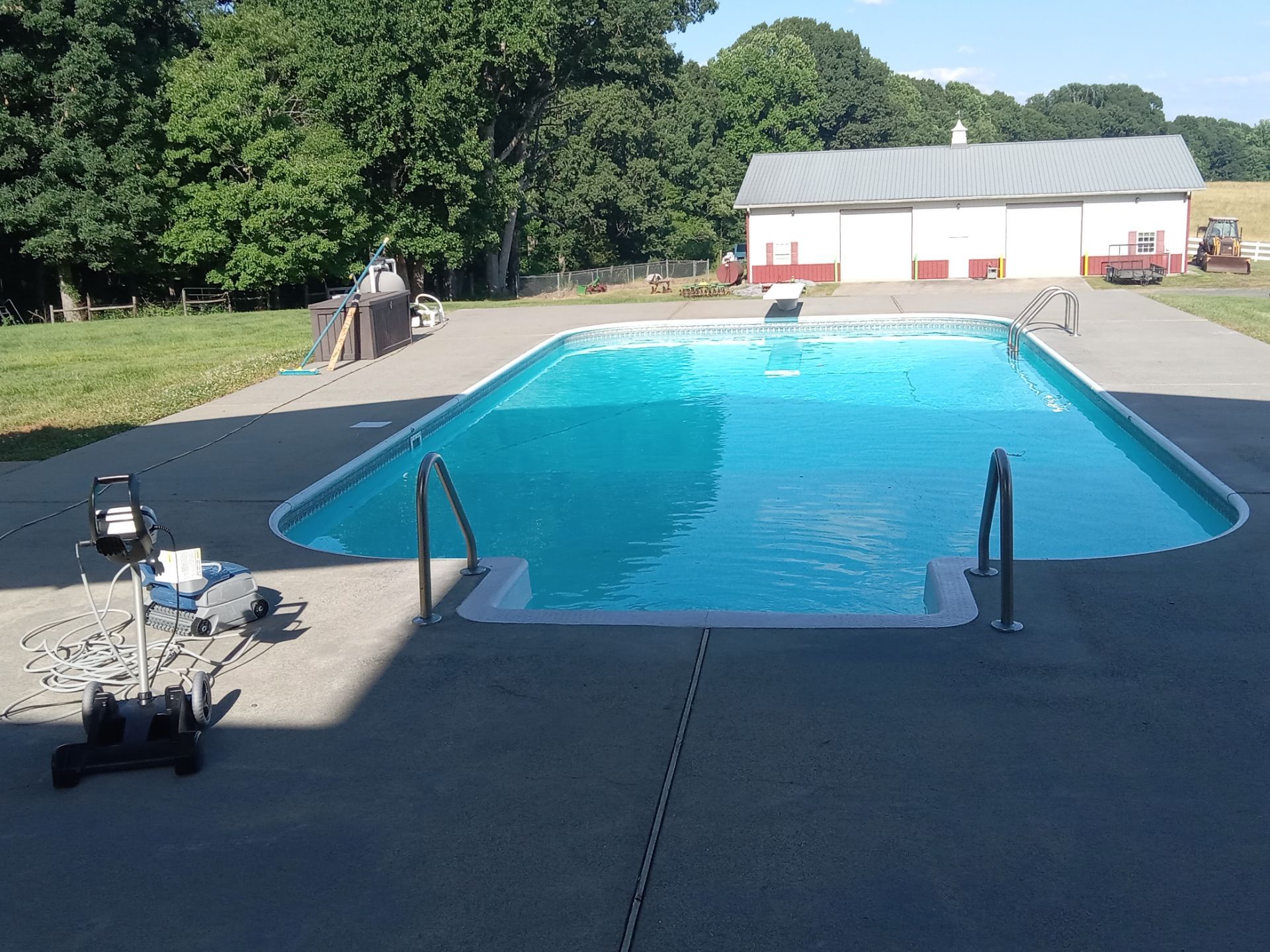 pressure washing concrete pool deck surrounding inground swimming pool cleaning dirt and stains