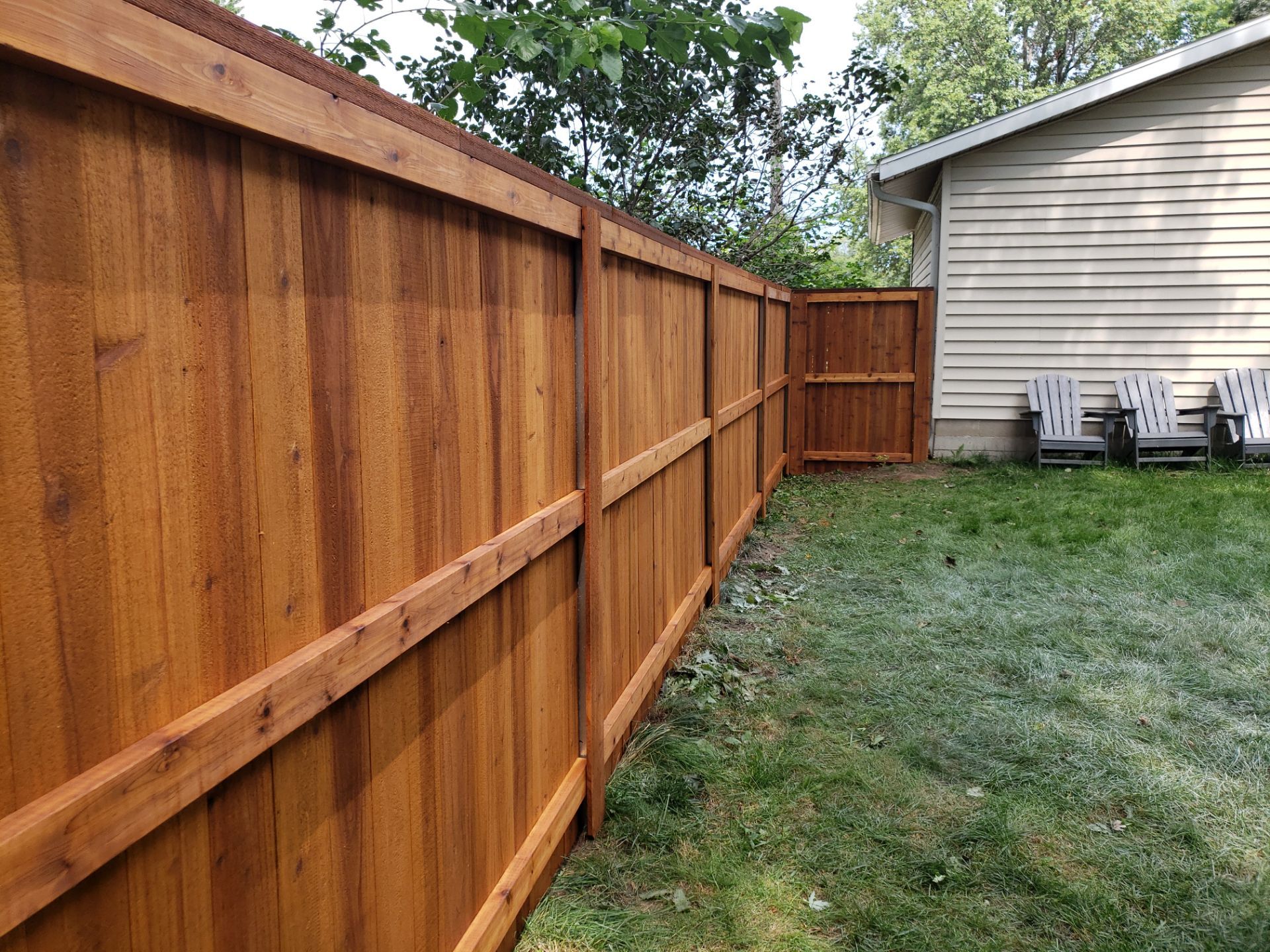 Custom Cedar Privacy Fence with Decorative Gate Windows in Cedar Falls by Perfect Picket Fence and Stain