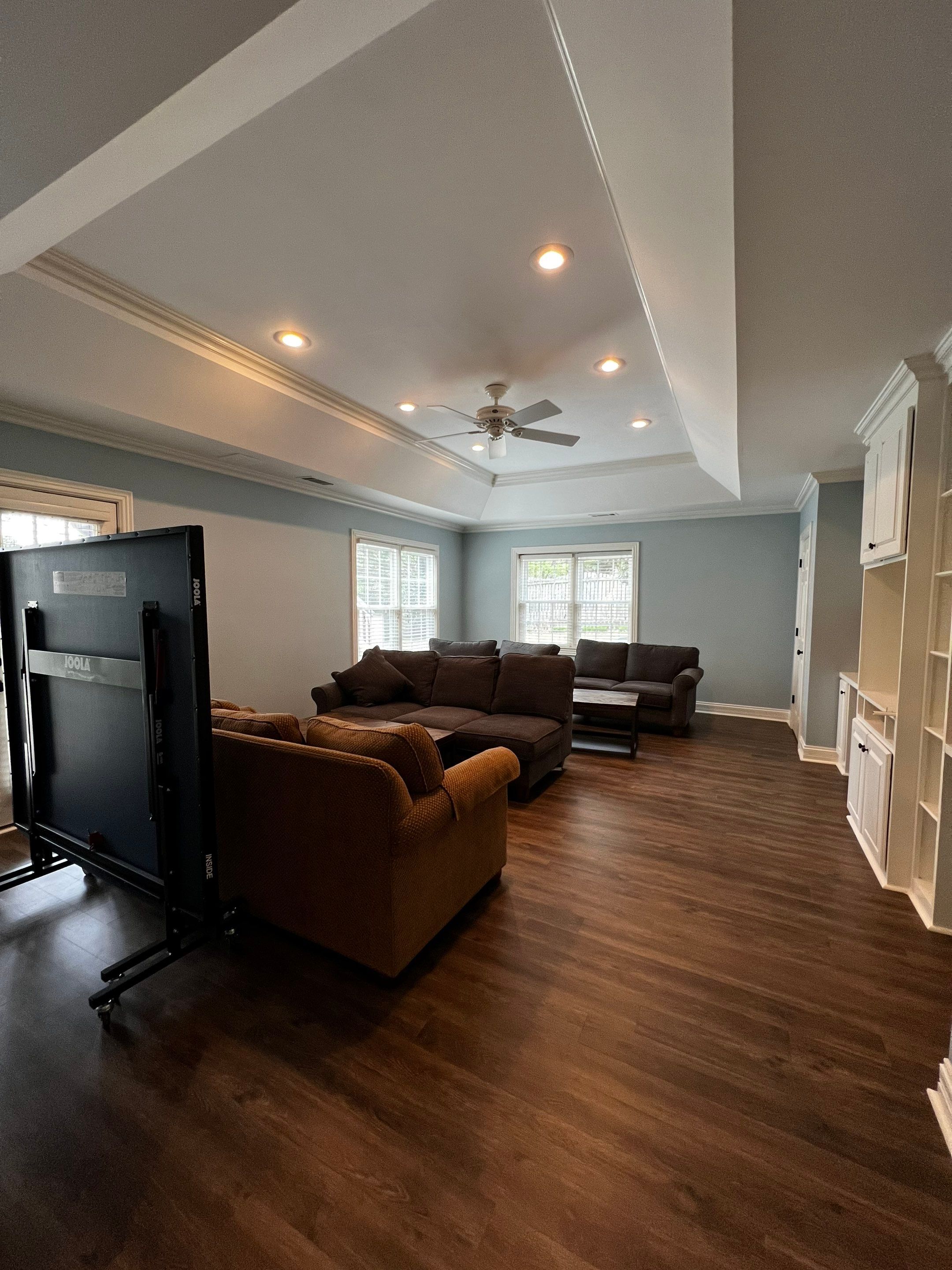 Finished Basement Remodeling with Dark Wood-Look Flooring and Custom Wainscoting by Swift Home Renovations 