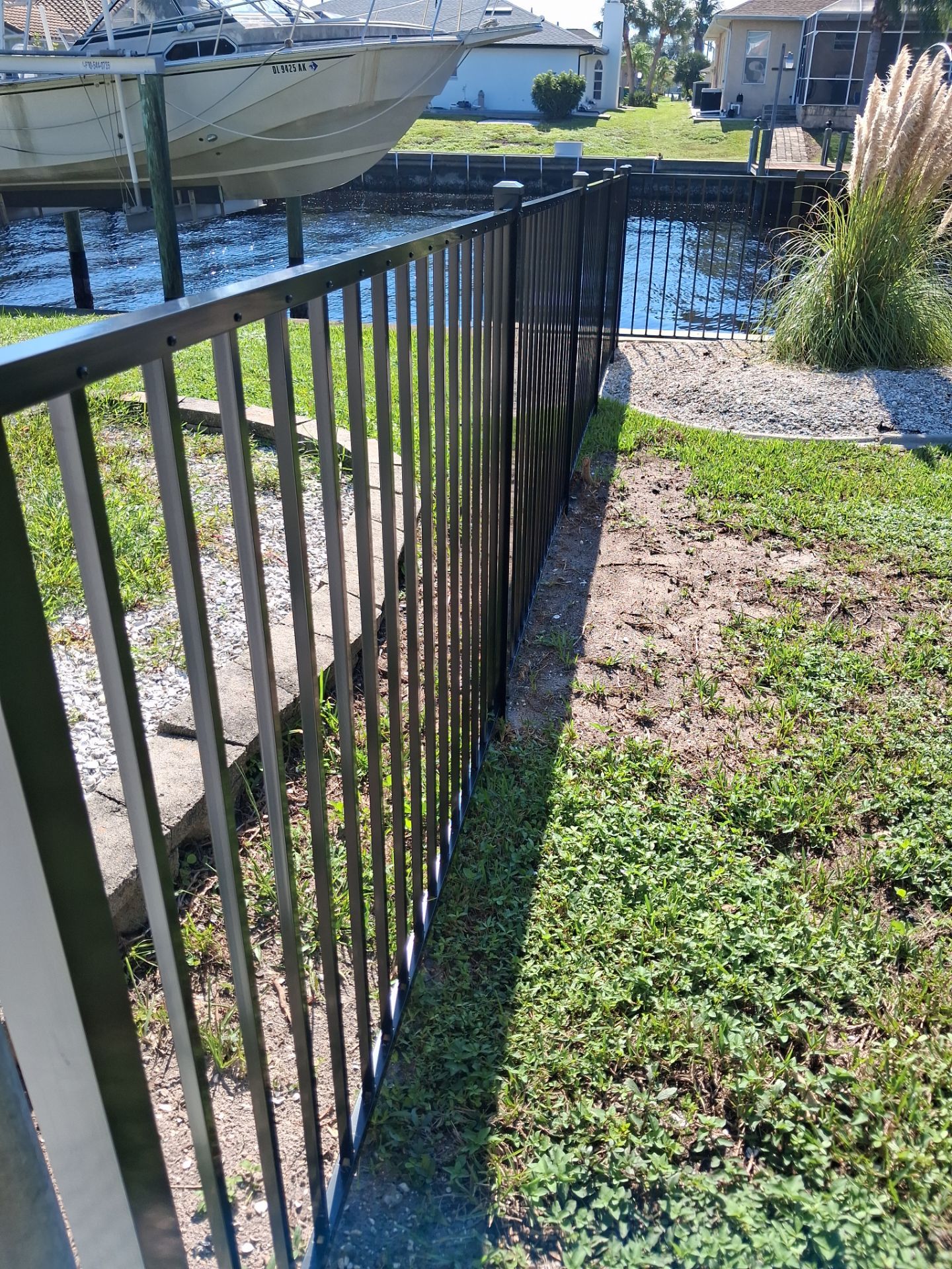 Black Aluminum Picket Fence Installation for Port Charlotte Canal Home by True Fence LLC