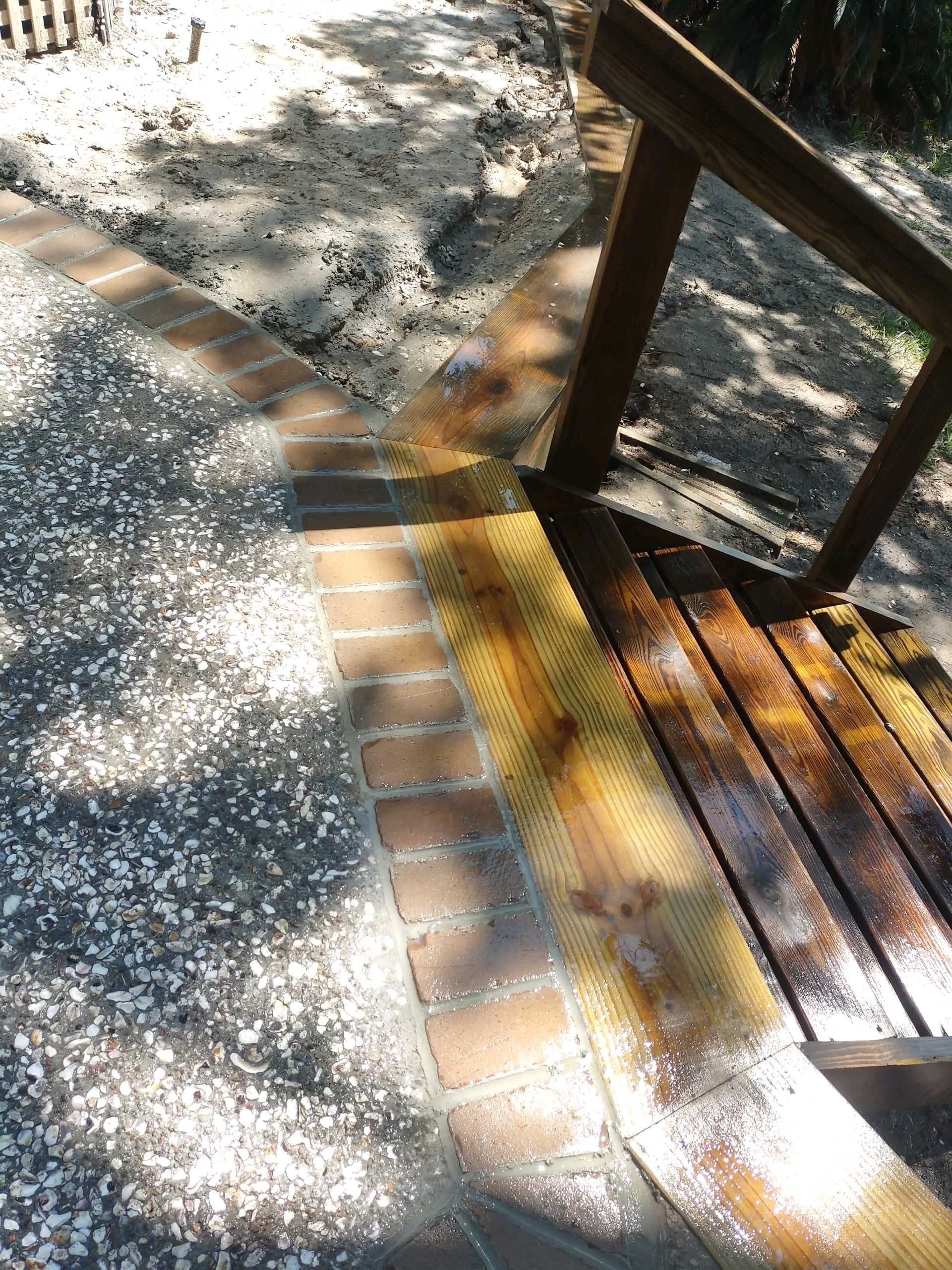 Exposed Aggregate Patio with Brick Inlays and Retaining Wall in Okatie by Lowcountry Scapes, LLC
