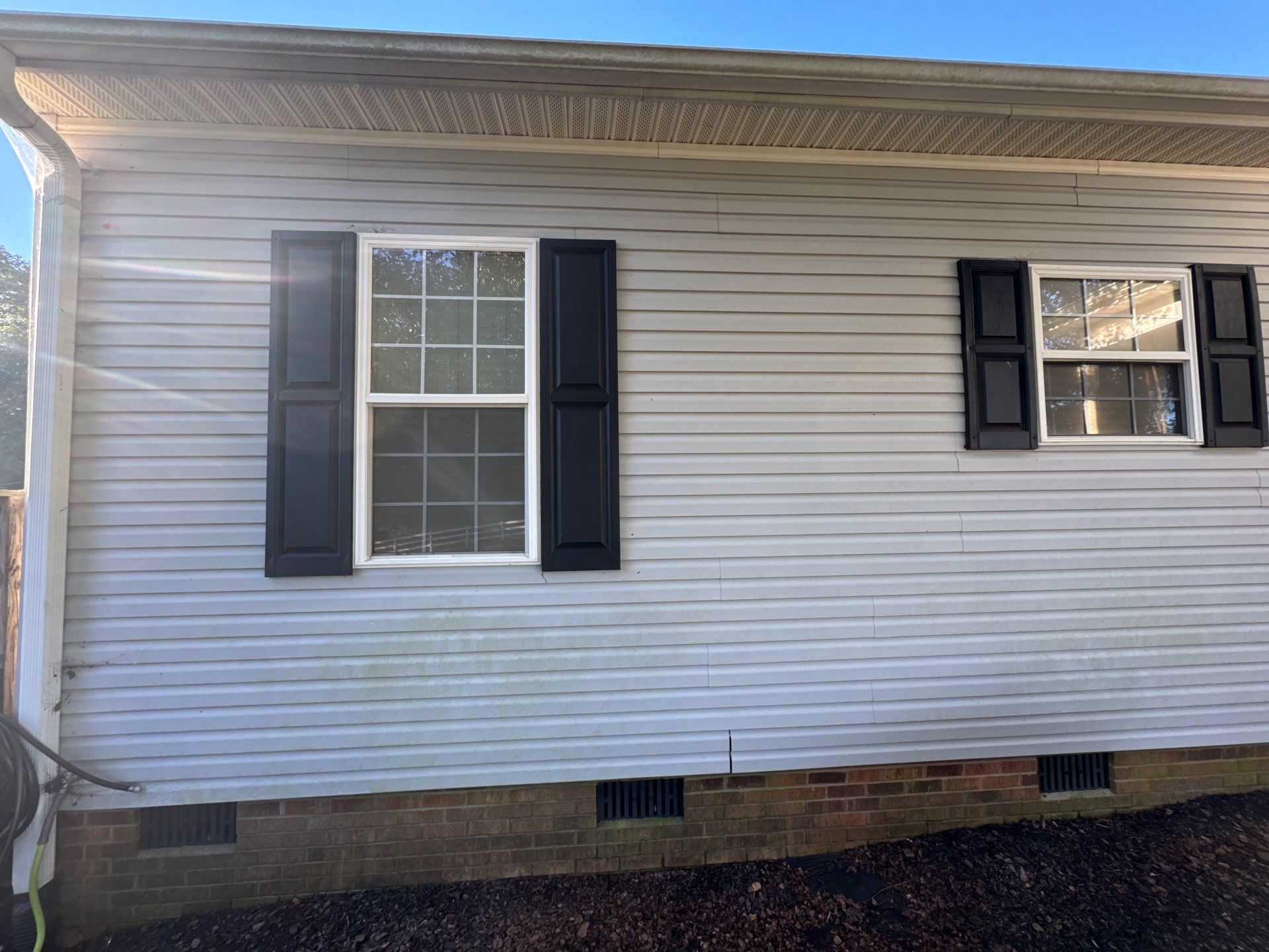 the service being done is cleaning the exterior siding of a house removing dirt and grime from the surface