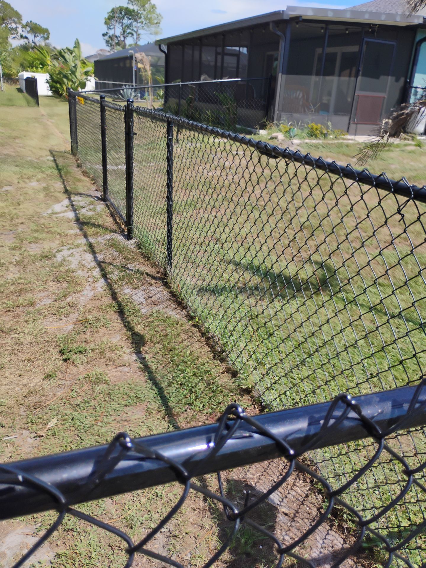Black Vinyl-Coated Chain Link Fence and Rolling Gate Installation in North Port by True Fence LLC