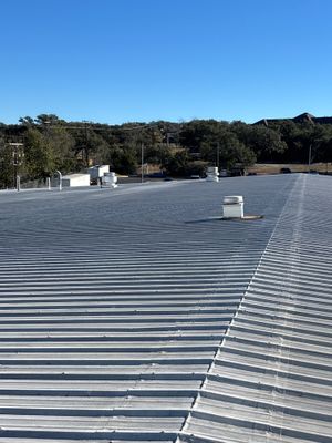 Wide view of completed metal roof with vents