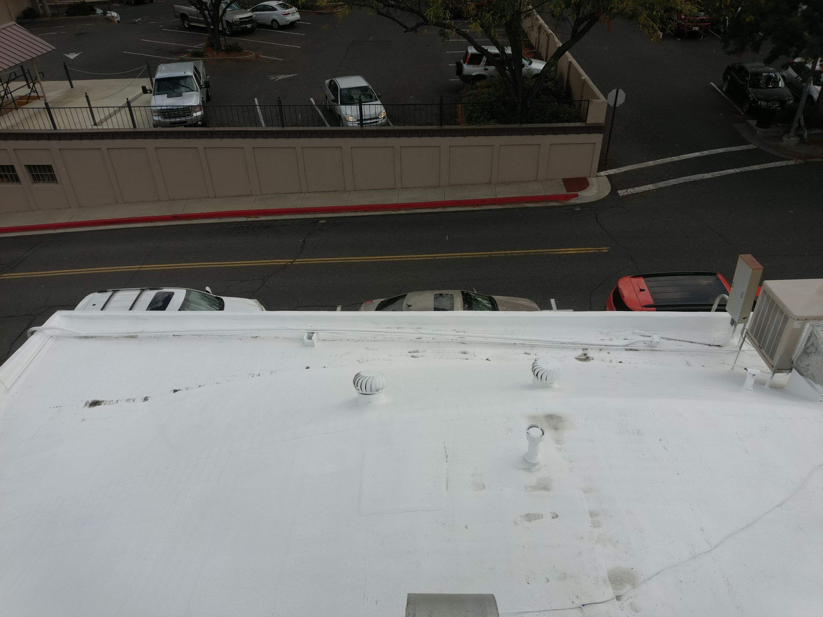 Foam and coatings on commercial roof by Straight Edge Roofing Inc