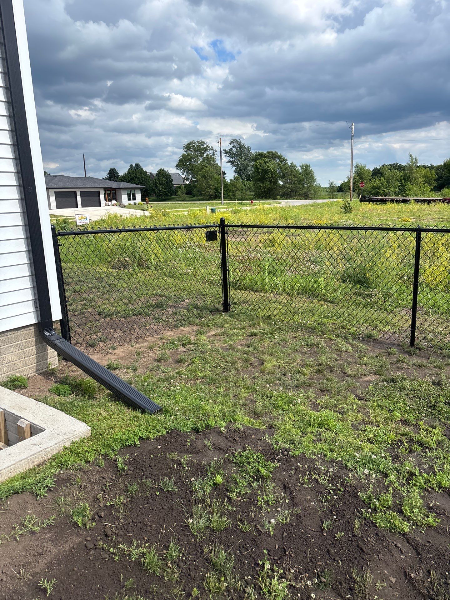Black Vinyl-Coated Chain Link Fence and Residential Site Grading by Perfect Picket Fence and Stain