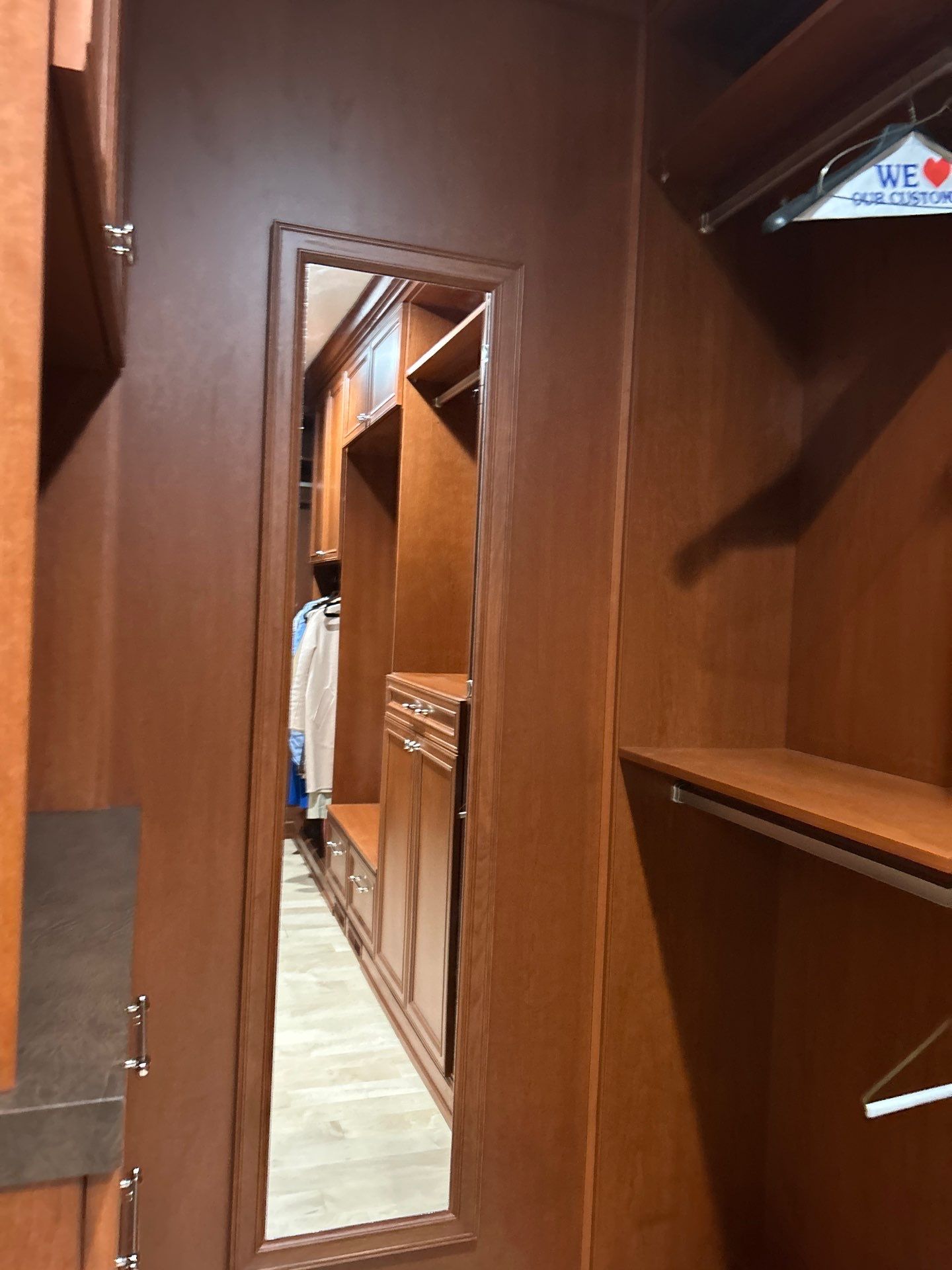 Stained Cherry Wood Primary Closet by Concept 32, Inc.