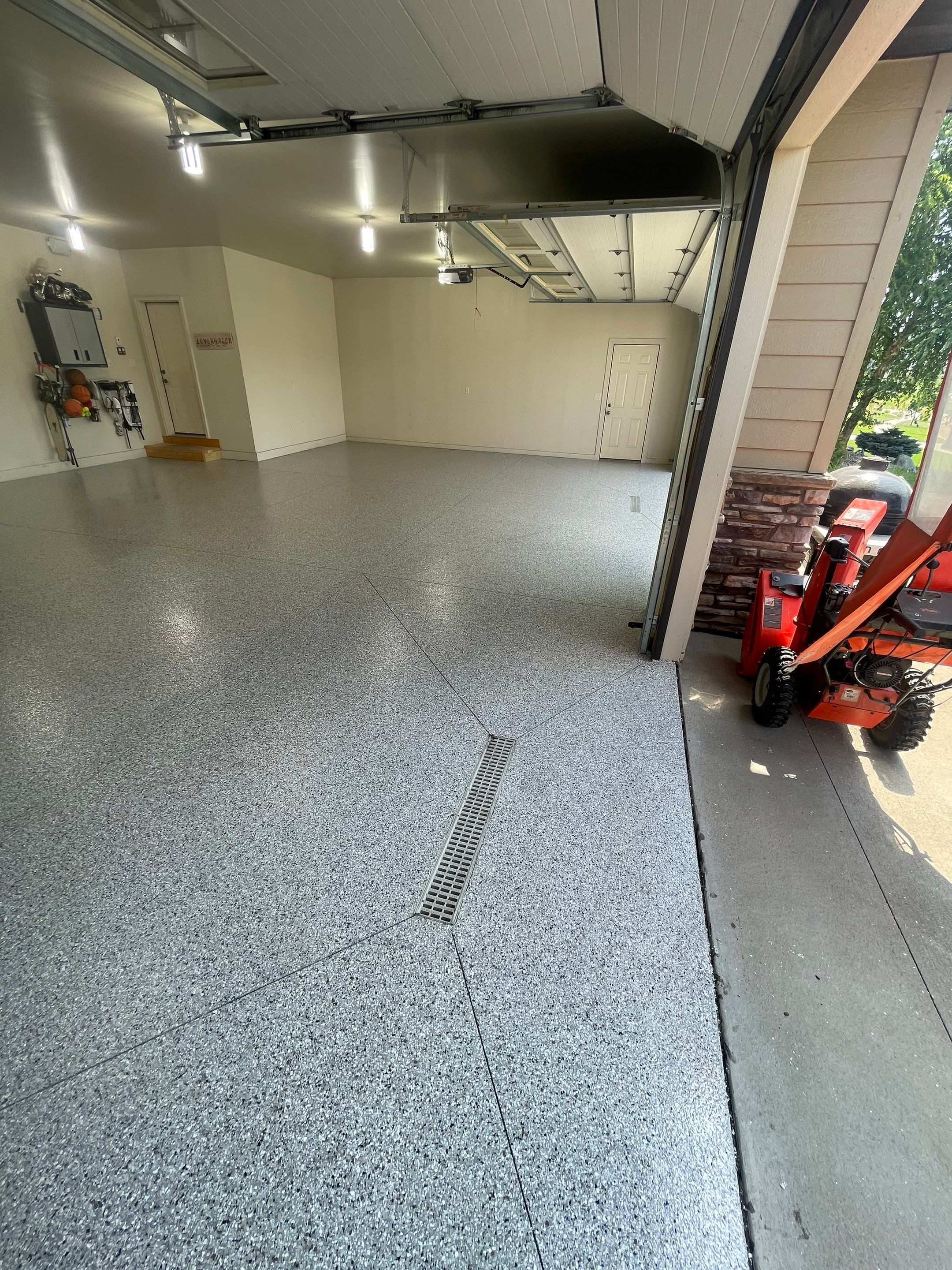 Coyote Flake Garage Floor Coating in Sioux Falls with Trench Drain by Select Painting, Coatings & Garage Cabinets