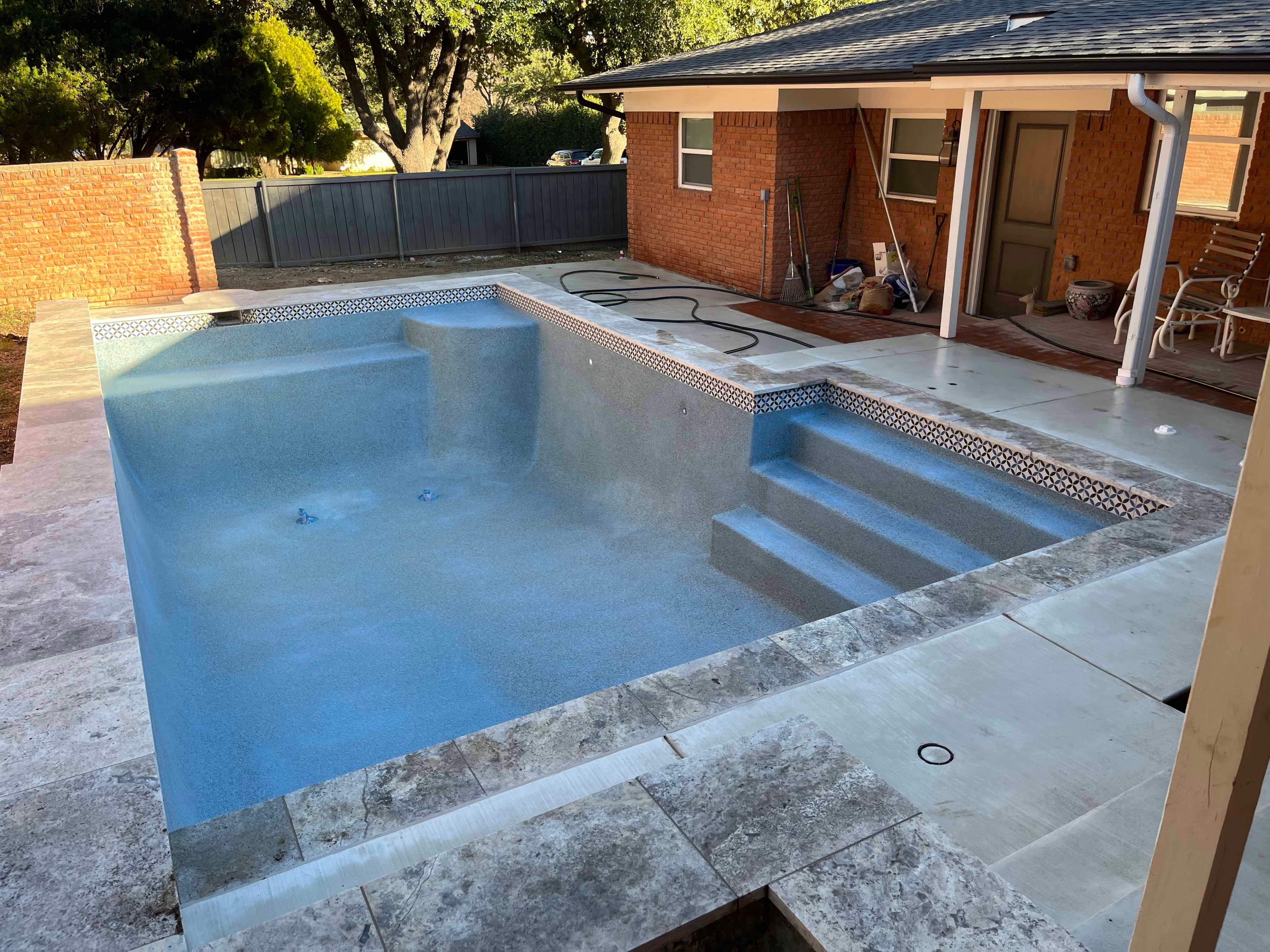Geometric Pool with Raised Stone Wall and Sheer Descent by Pinnacle Pools and Spas - DFW