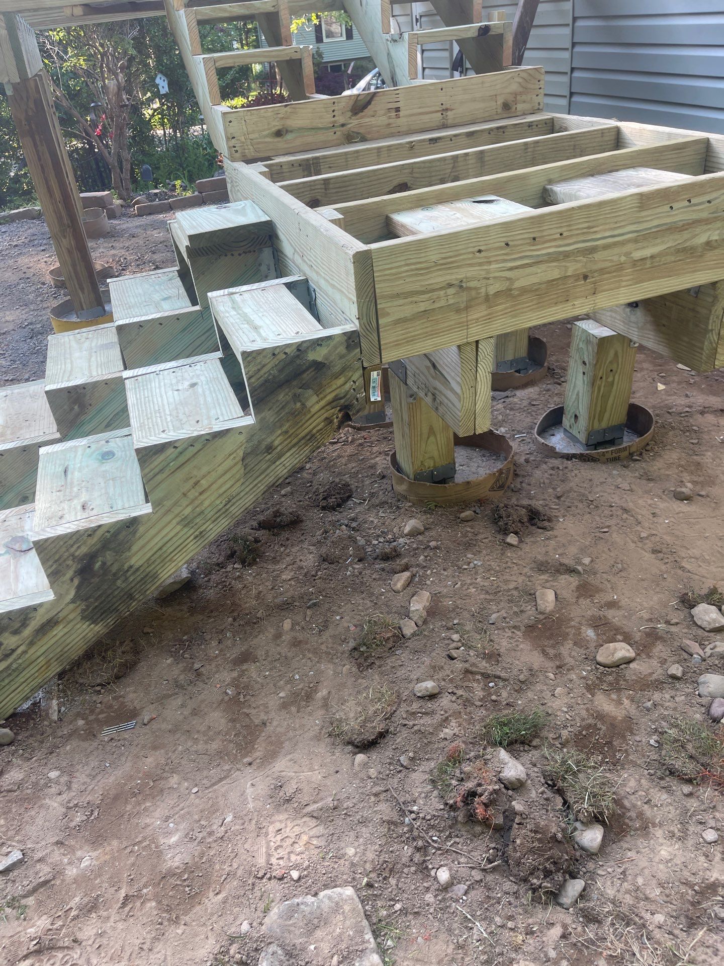 Raised Gray Composite Deck and Staircase Construction in Pocono Summit, PA by Herts Roofing & Construction