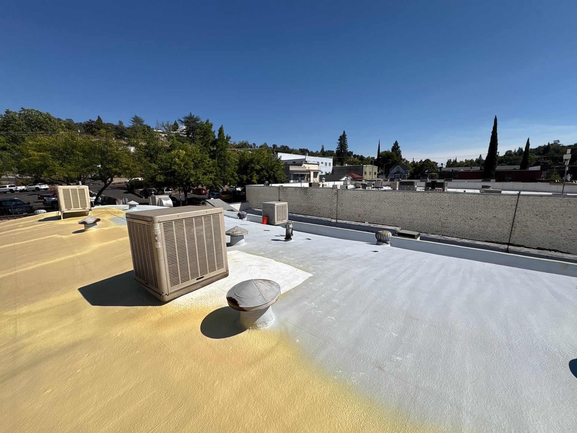 Foam and coatings on commercial roof by Straight Edge Roofing Inc