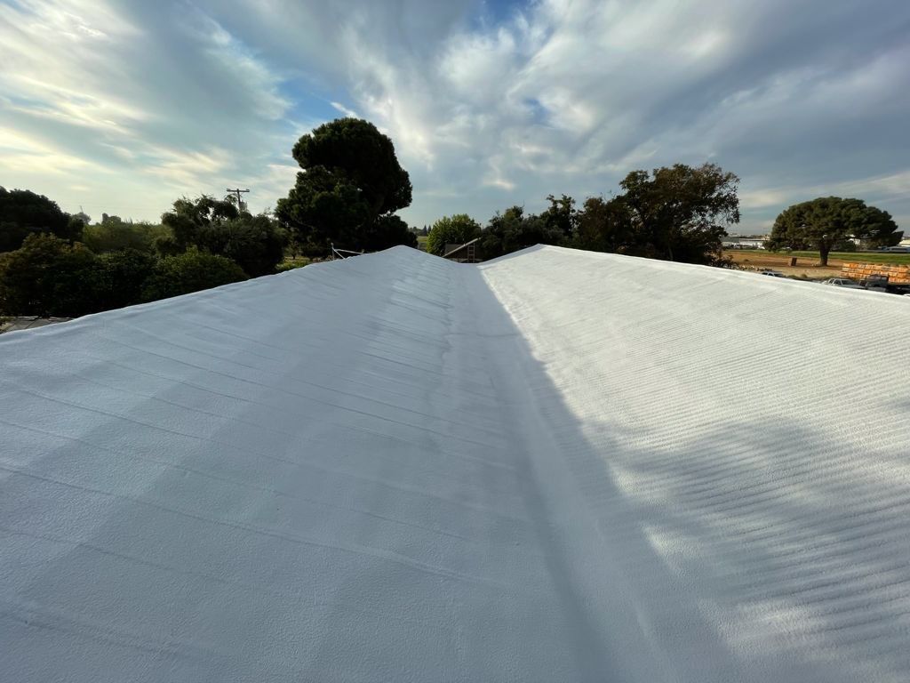 Metal roof sprayed with polyurethane spray foam and coatings by Straight Edge Roofing Inc