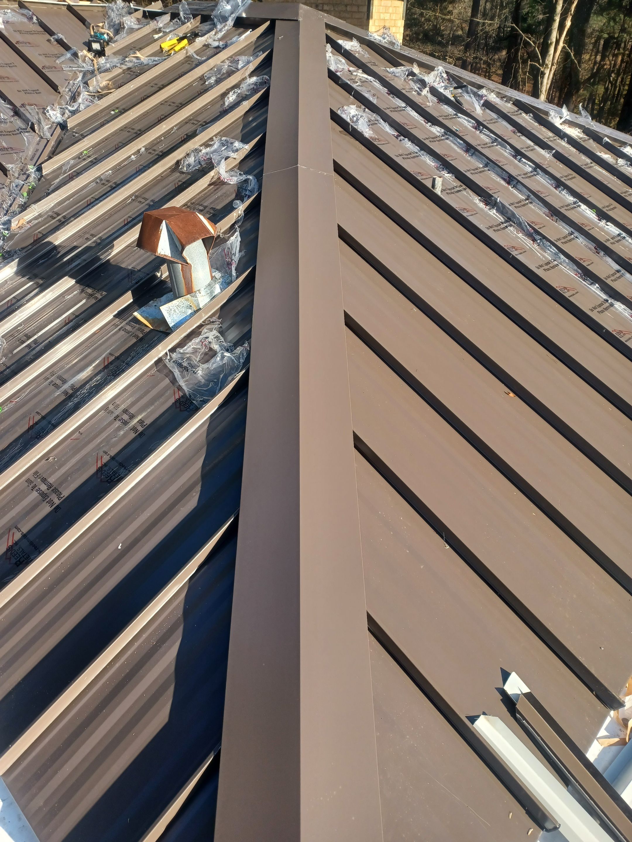 Residential Roofing Installation using PVC membrane and 24 gauge Standing Seam Metal by Hostetler Roofing