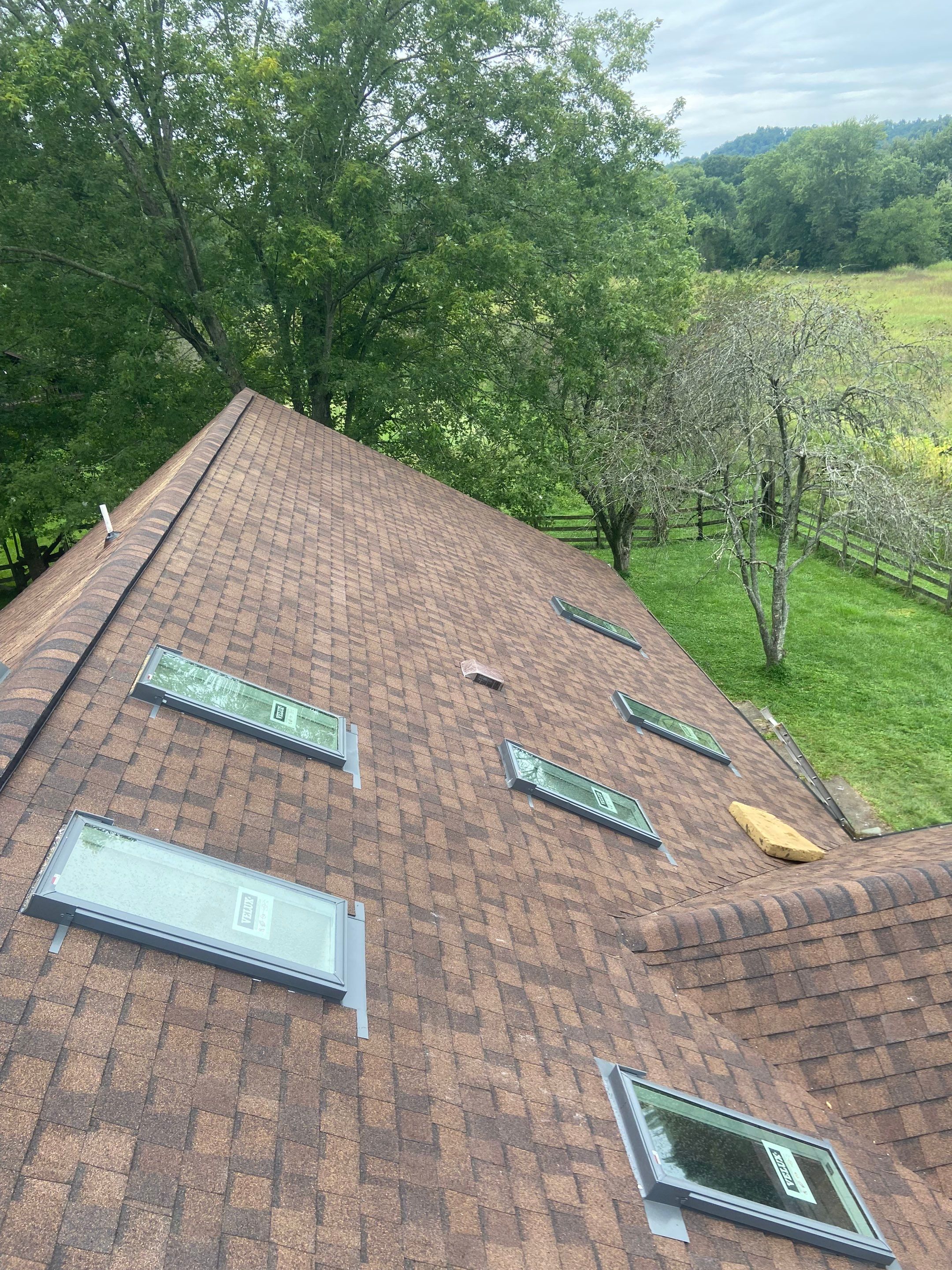Shingle Roofing with Velux Skylight replacement and stone chimney flashing  by Secure Construction Company Inc