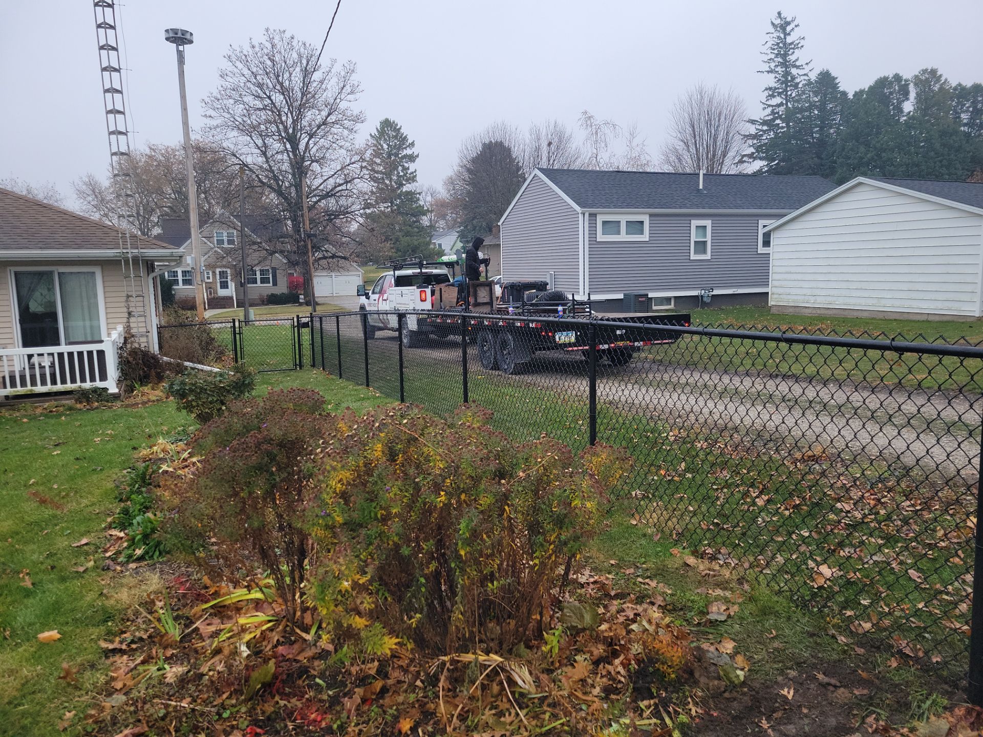 Black Vinyl-Coated Chain Link Fence Installation in Aplington by Perfect Picket Fence and Stain