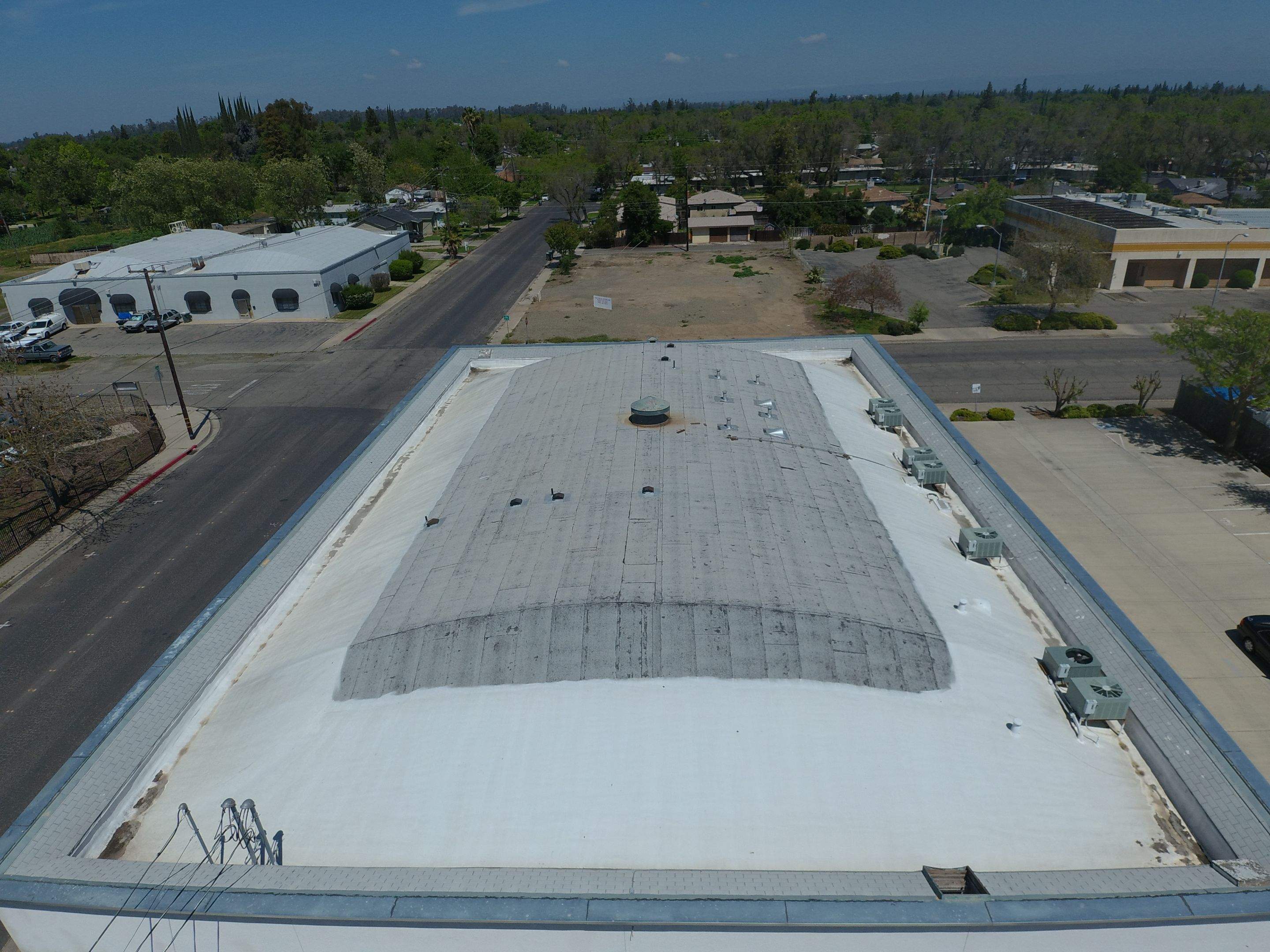 Spray foam and coatings using Conklin Benchmark/PUMA XL coatings on Auto Body Shop by Straight Edge Roofing Inc
