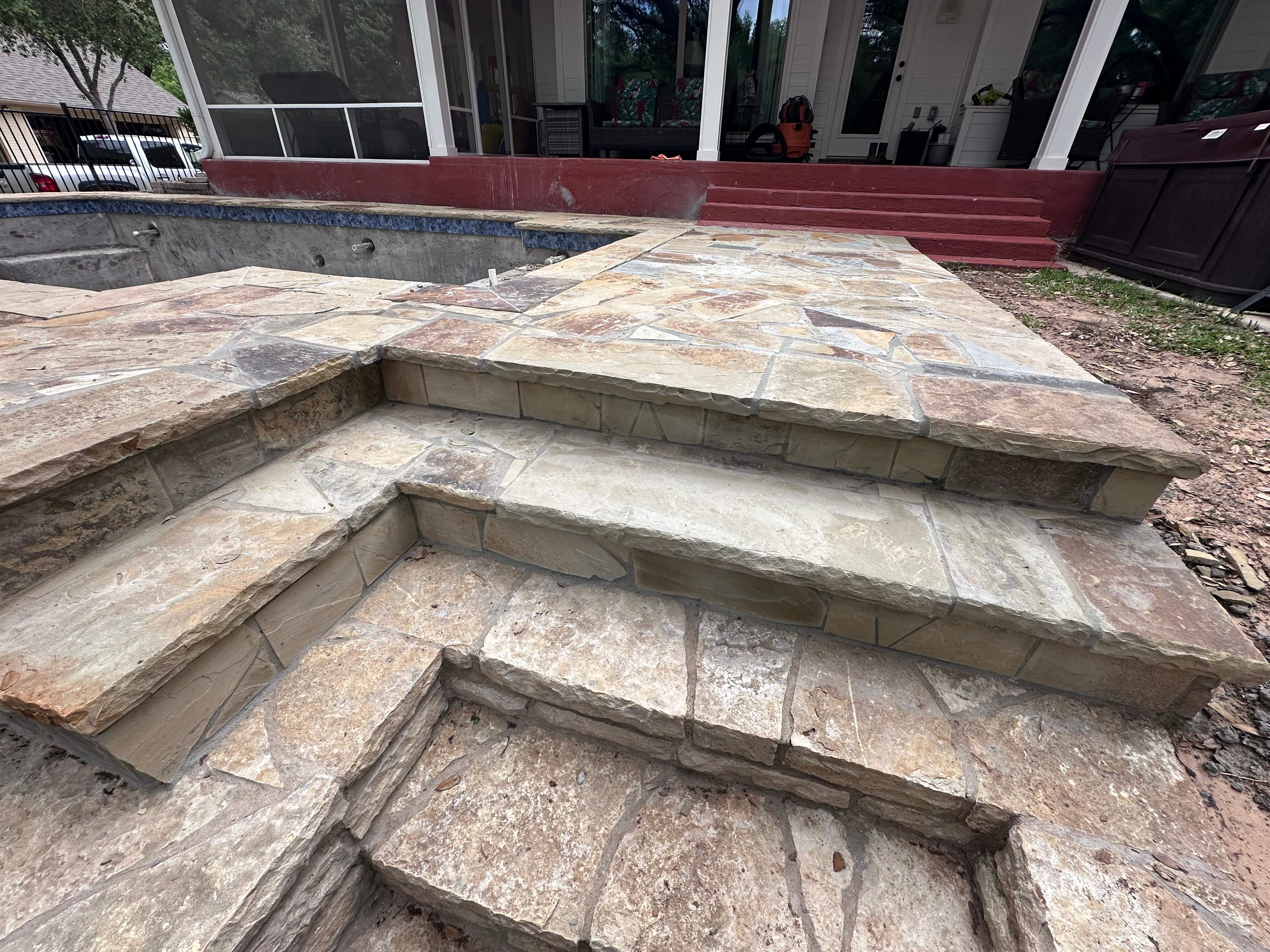 Geometric Pool with Raised Stone Wall and Flagstone Decking by Pinnacle Pools and Spas - DFW