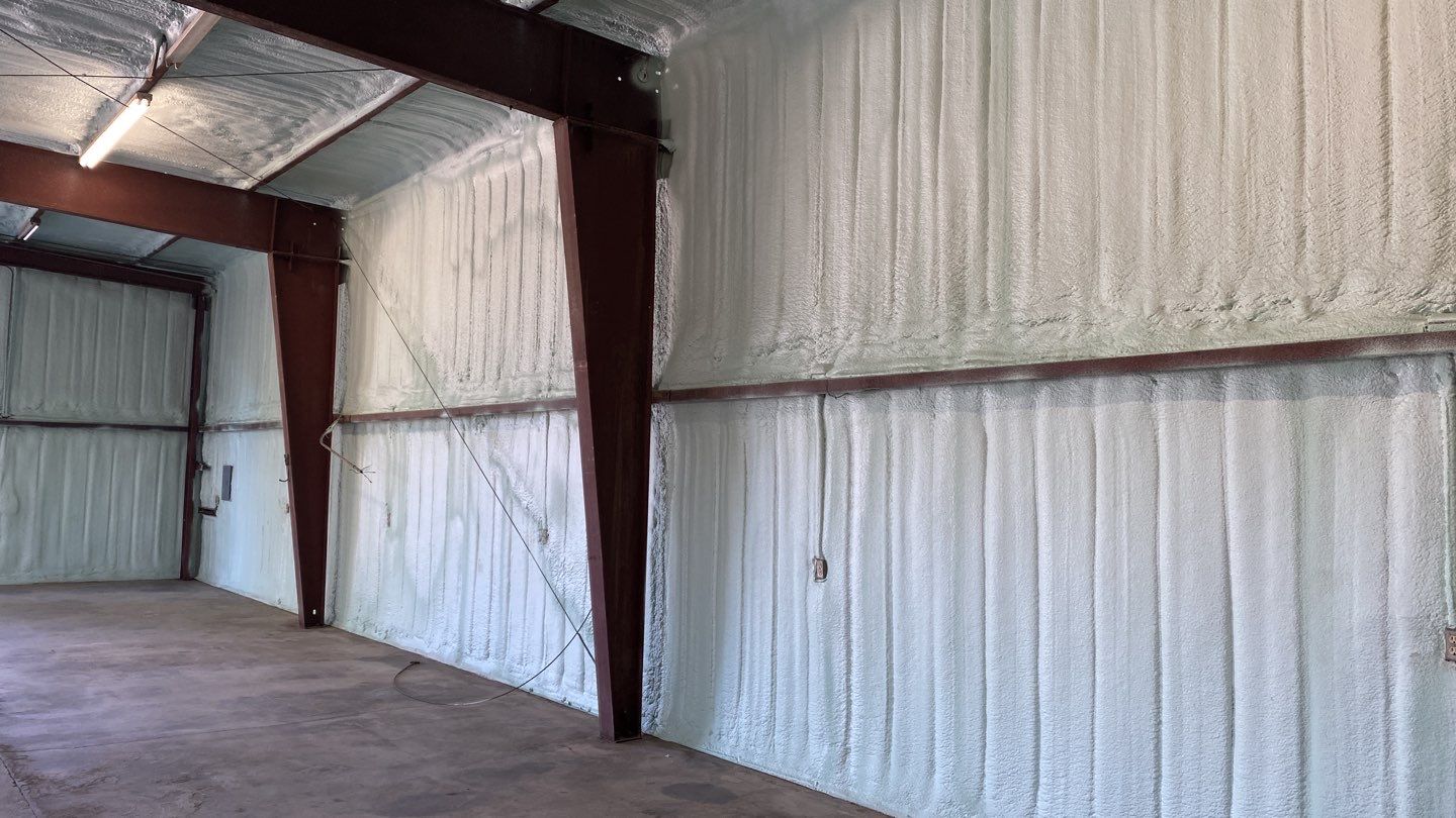 Spray foam insulation on inside of metal industrial building by Straight Edge Roofing Inc