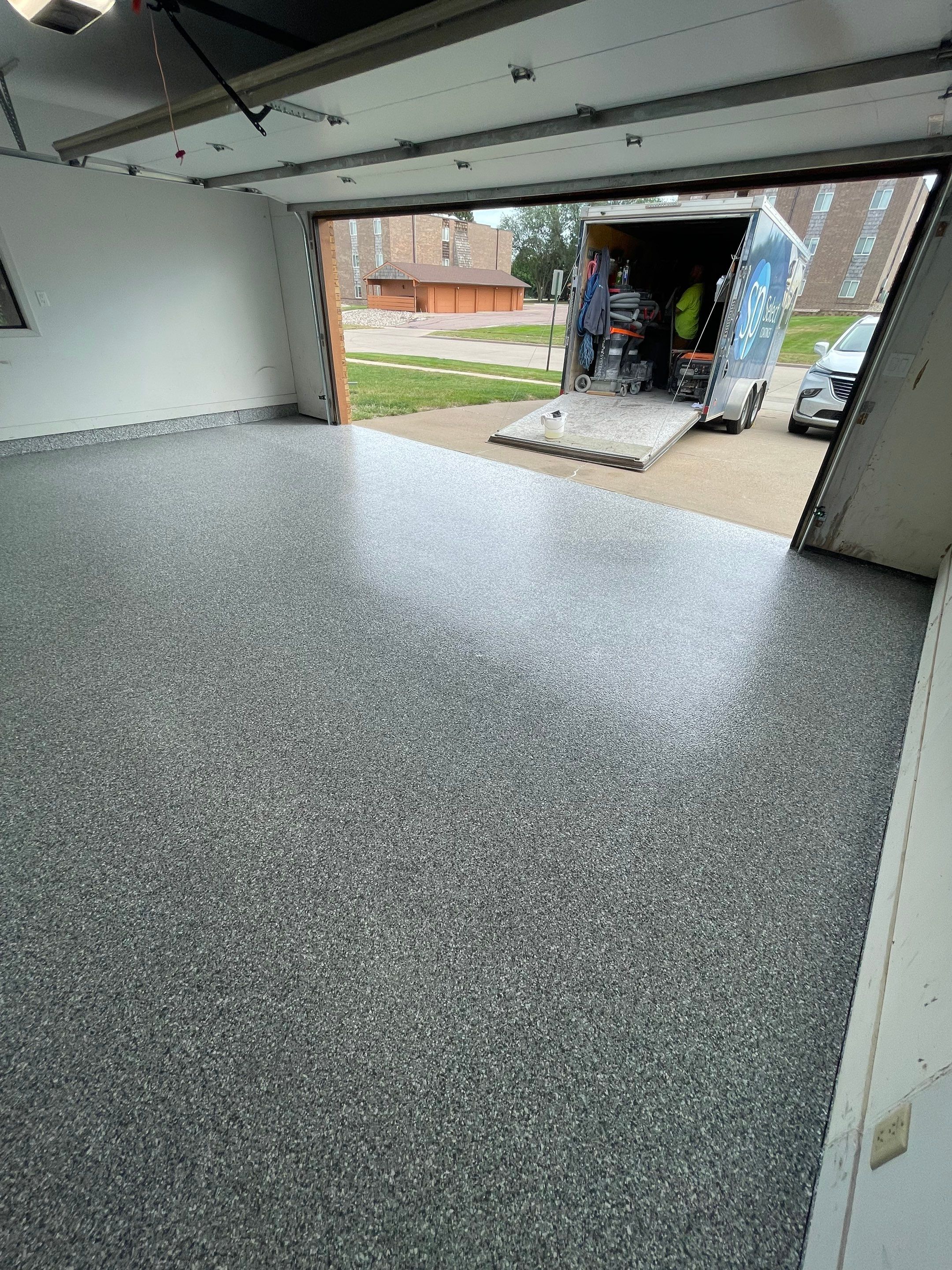 Grey Speckled Concrete Coating for Residential Garage in Yankton by Select Painting, Coatings & Garage Cabinets