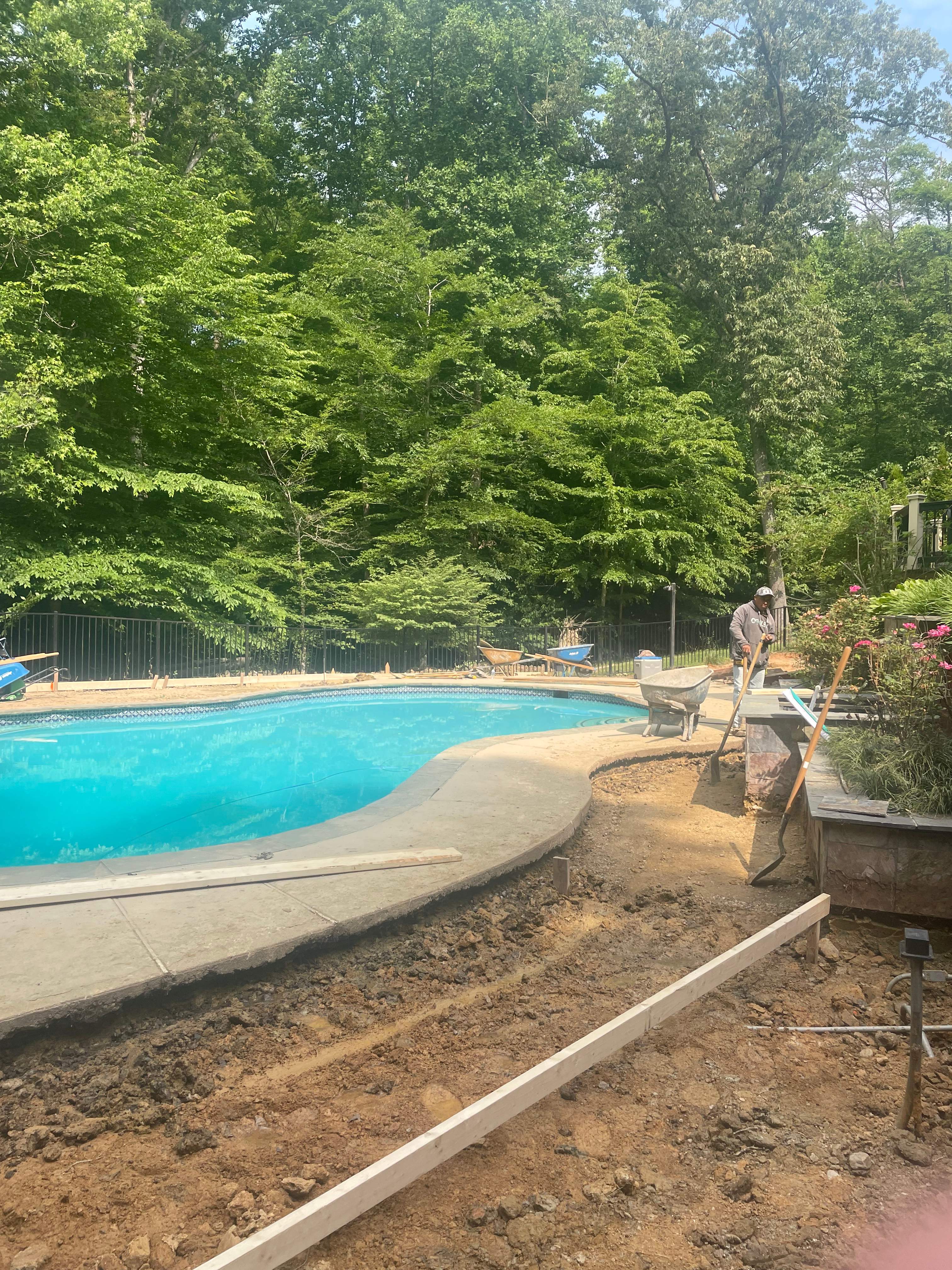 Pool Surround remodel with retaining walls, new waterfall and water slide by Fairfax Contractors, LLC