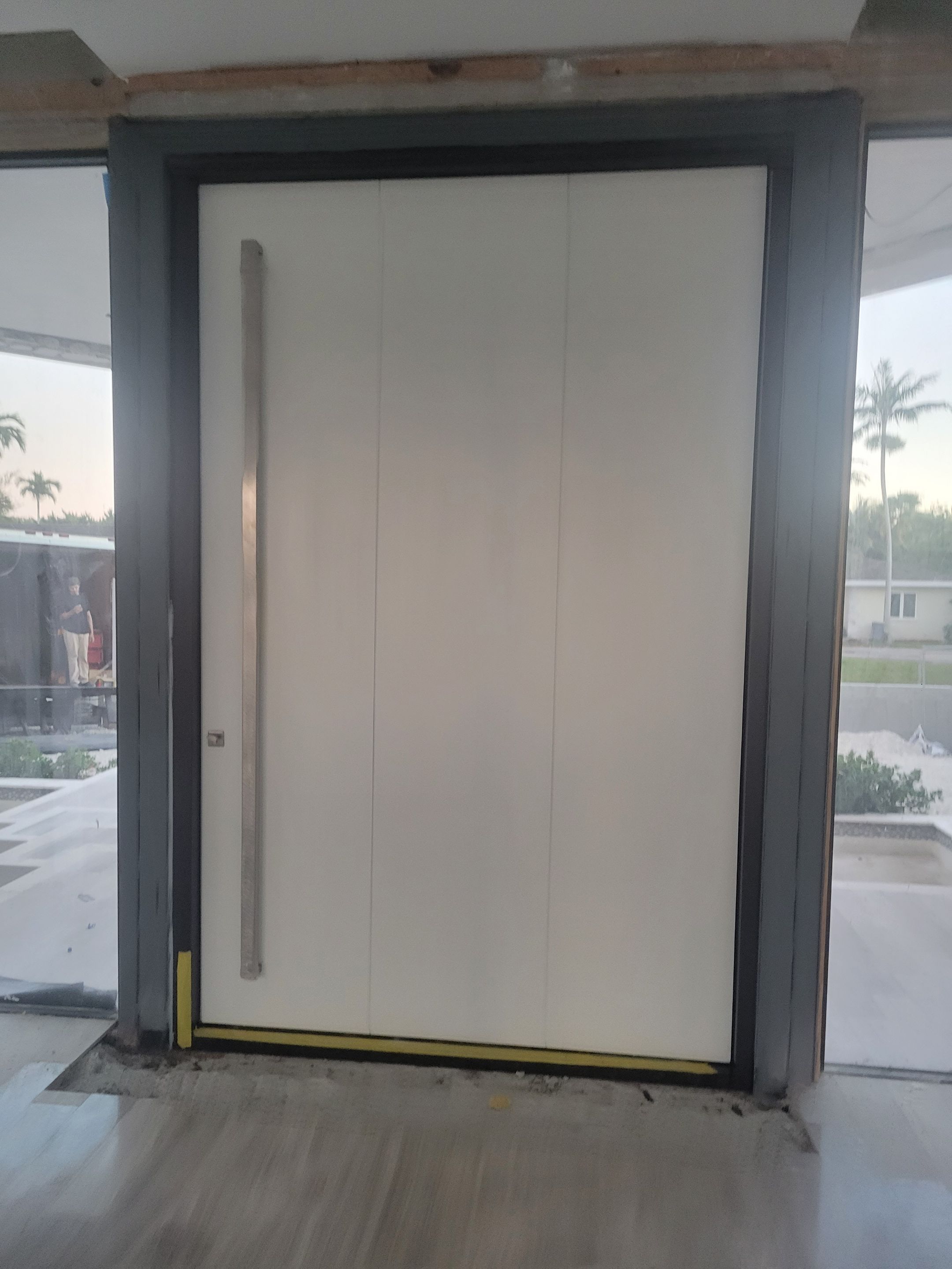 Custom Material Pivot Door installation by Impact Precious Wood Inc.