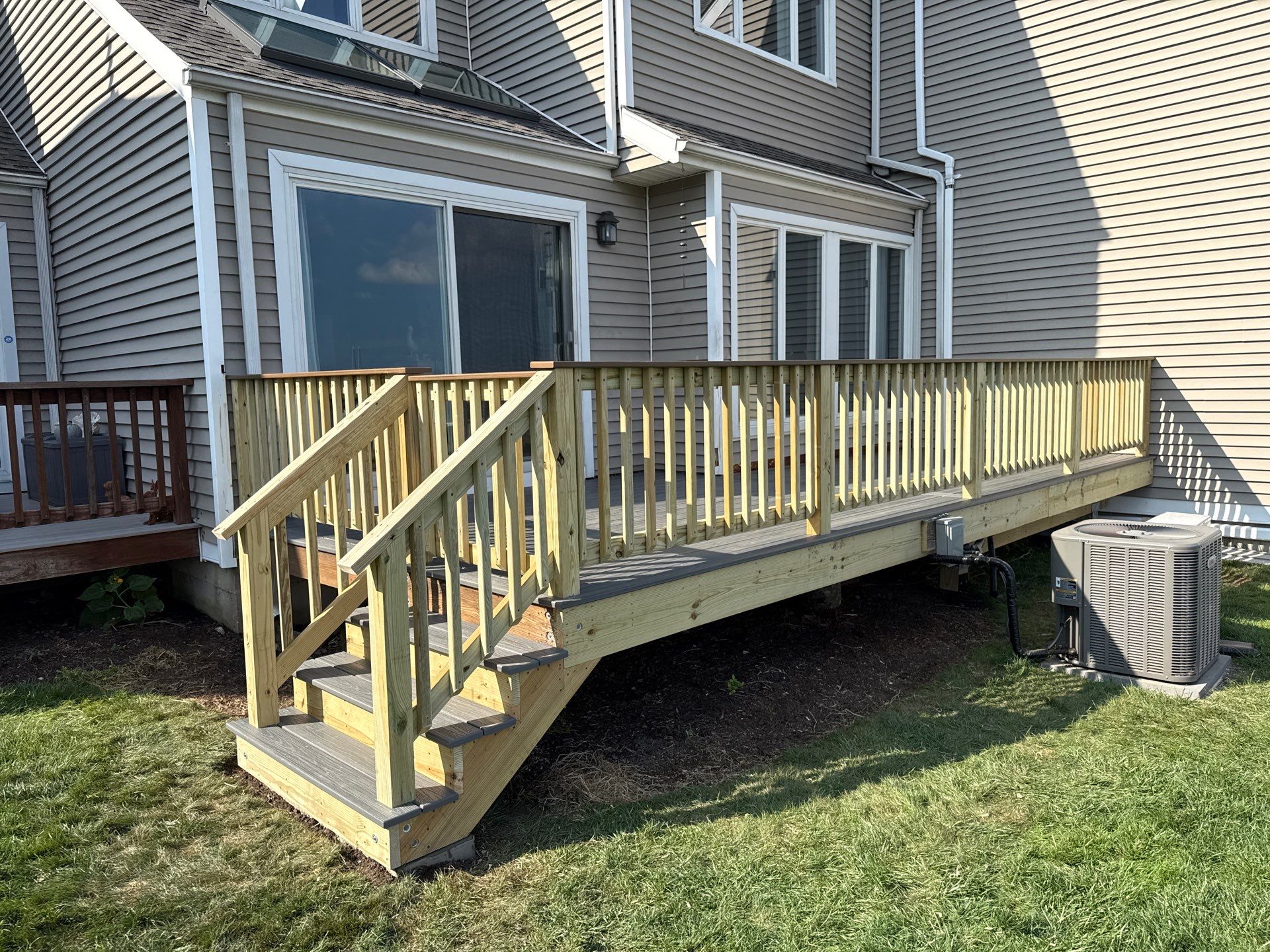 Deck replacement using trex Tropical Island mist and Pressure treated railings. by DiGiorgi Roofing and Siding Inc