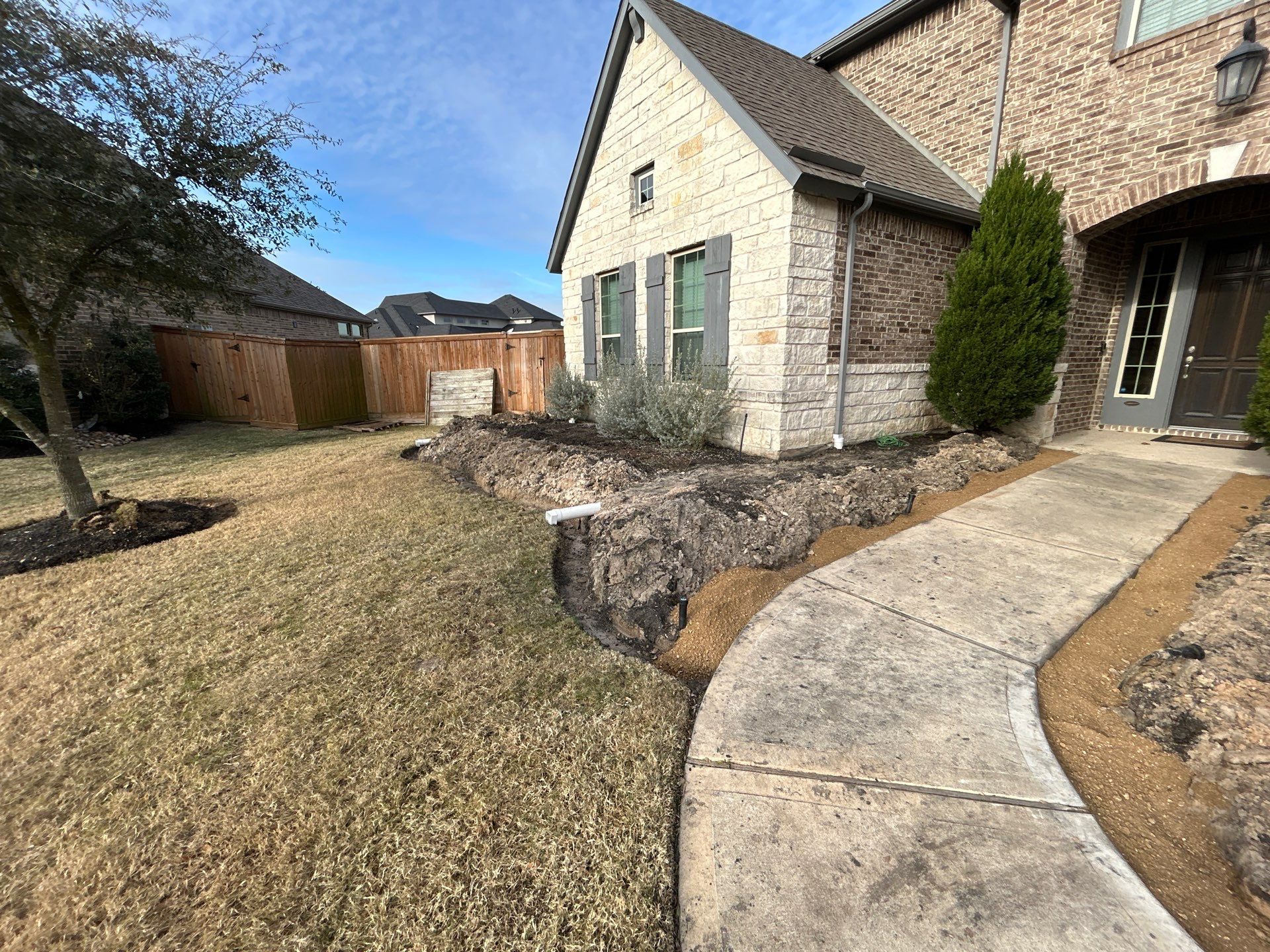 🌿✨ Darlene & Andrew’s Amazing Curb Appeal Transformation  Some projects are more than just landscaping—they’re a conversion of curb appeal from the ground up. For Darlene & Andrew, Alejandro and the Texas Urban Team designed and delivered a complete solution that reshaped their flower beds, solved drainage challenges, and gave new life to the sideyard.  💡 From planning to execution, every step was tailored to build both beauty and functionality:  🌸 Flower Beds, Reinvented  Demolition of old beds, plants, and mulch.  Fresh soil preparation, weed protection, and a brand-new retainer wall built with hand-cut stone and decorative caps.  Carefully selected plants and garden mix to ensure health and visual harmony.  💧 Drainage & Irrigation Upgrades  Outdated corrugated pipes replaced with PVC drainage lines to carry water safely away from the foundation.  New irrigation system combining drip lines and sprinklers—watering plants while keeping the house walls protected.  Sideyard drainage extended with catch basins and PVC piping to prevent water pooling and foundation stress.  🚶 Functional Sideyard with Walkway & Trash Area  Graded and leveled sideyard to manage runoff.  Installed a modern gravel and paver walkway for easy access.  Built a firm and tidy concrete-paver pad for trash containers—making the space both practical and polished.  🛠️ Stonework & Craftsmanship  Every stone in the retainer wall was cut, set, and secured by the team of handcrafters, ensuring a durable build that doubles as a design statement.  ✅ Outcome: Darlene & Andrew’s property now has better drainage, a clean and organized sideyard, and elegant new flower beds—all designed for long-term durability and lasting beauty.  📢 Before hiring anyone, review our portfolio. Our work speaks louder than words—each project is a blend of function, protection, and design crafted to last. by Texas Urban Elements