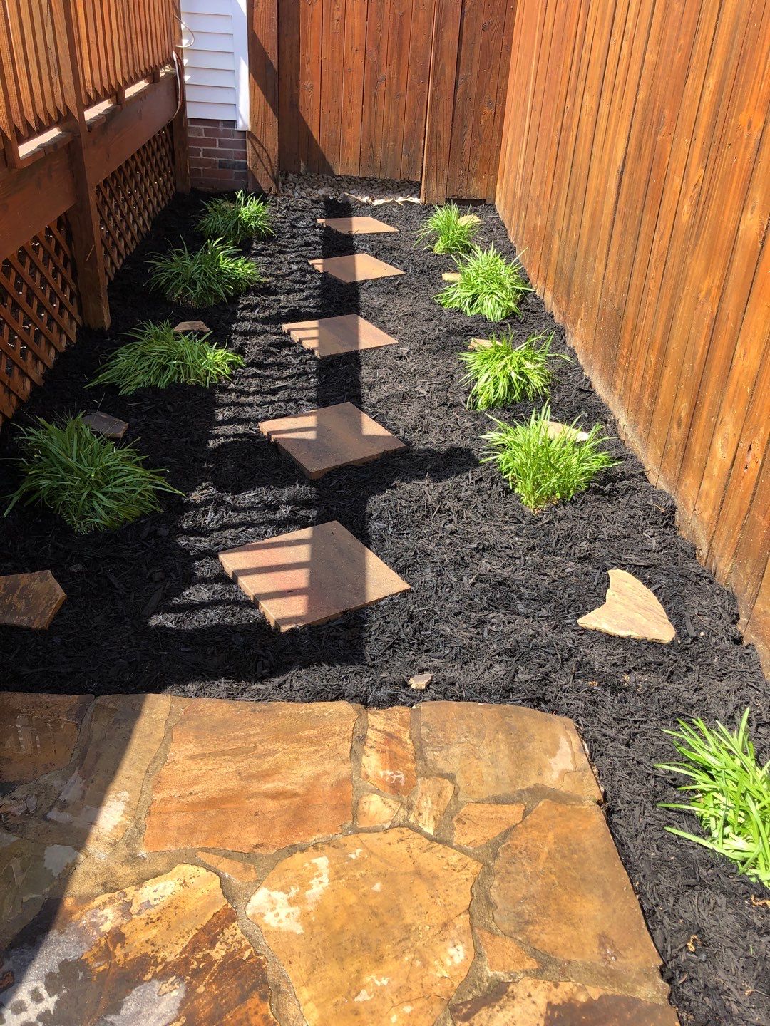 Liriope grasses, mulch and stone pavers by GrassBusters, Inc.