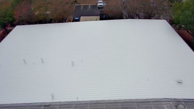 Aerial view of completed white flat roof on commercial building