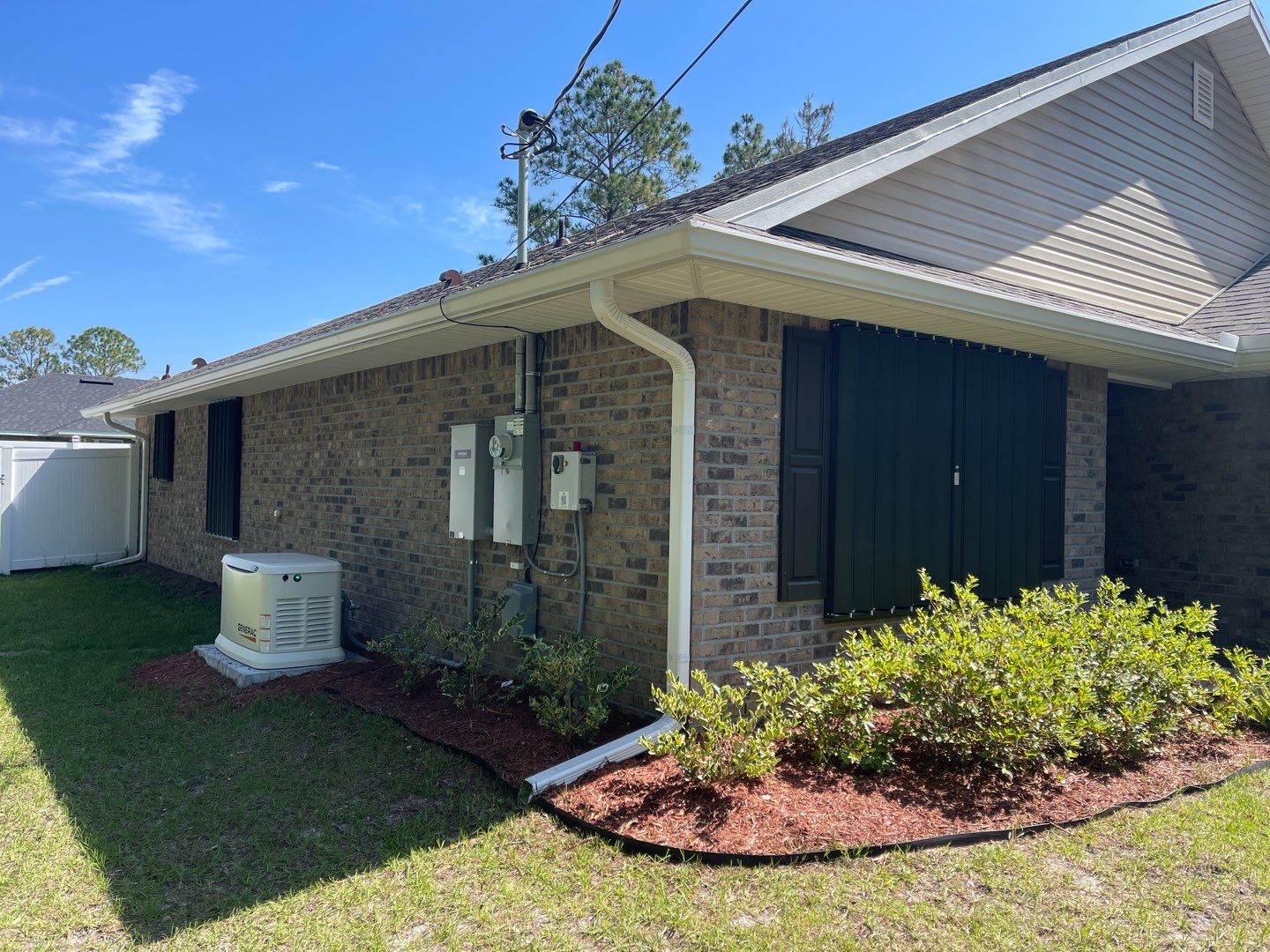Bronze Accordions on brick home by Smart Guard Shutters