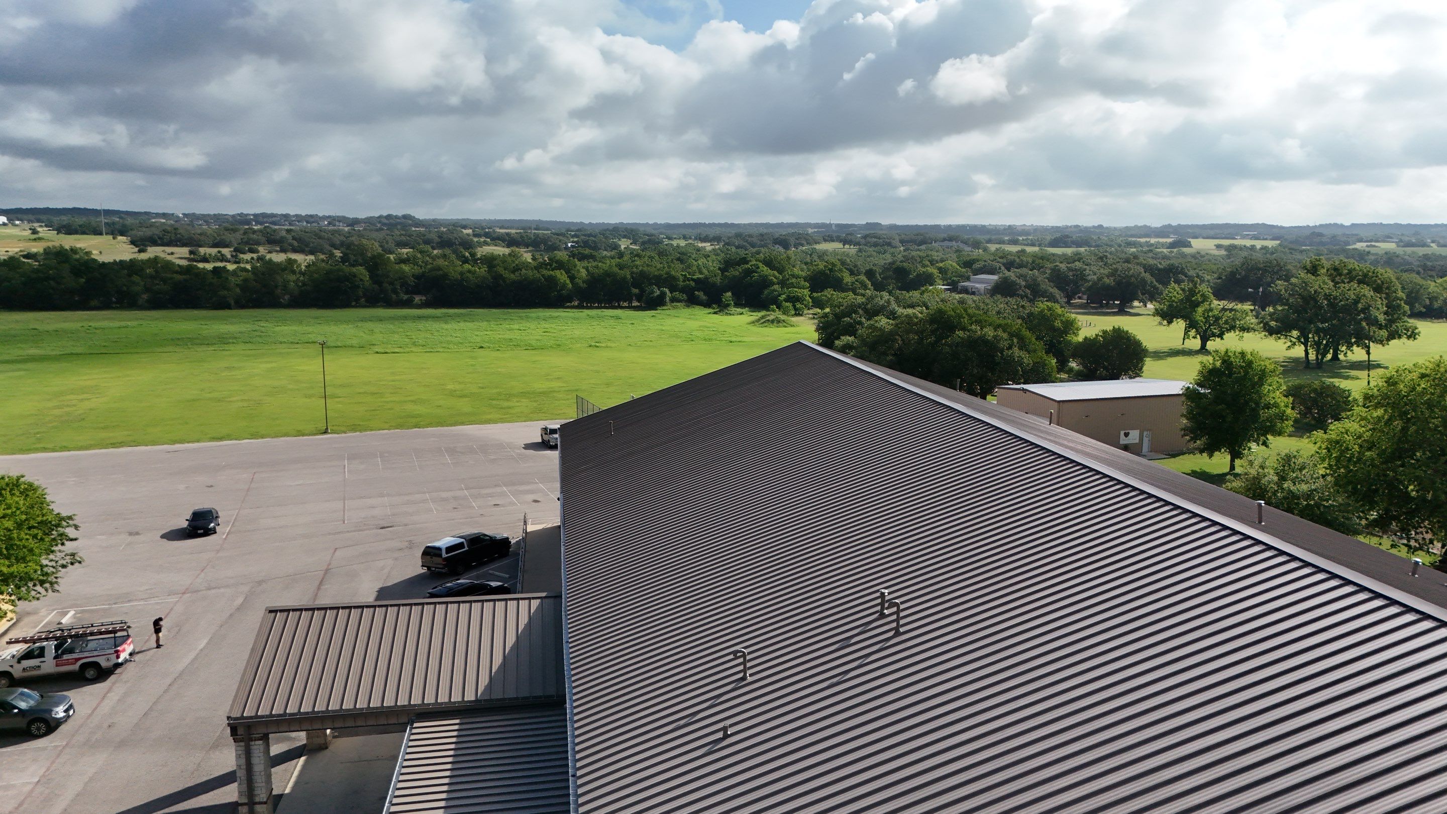 Commercial Roofing Installation using 24 GA 2" Seam Metal Retrofin - Buckskin by Action Exteriors Austin