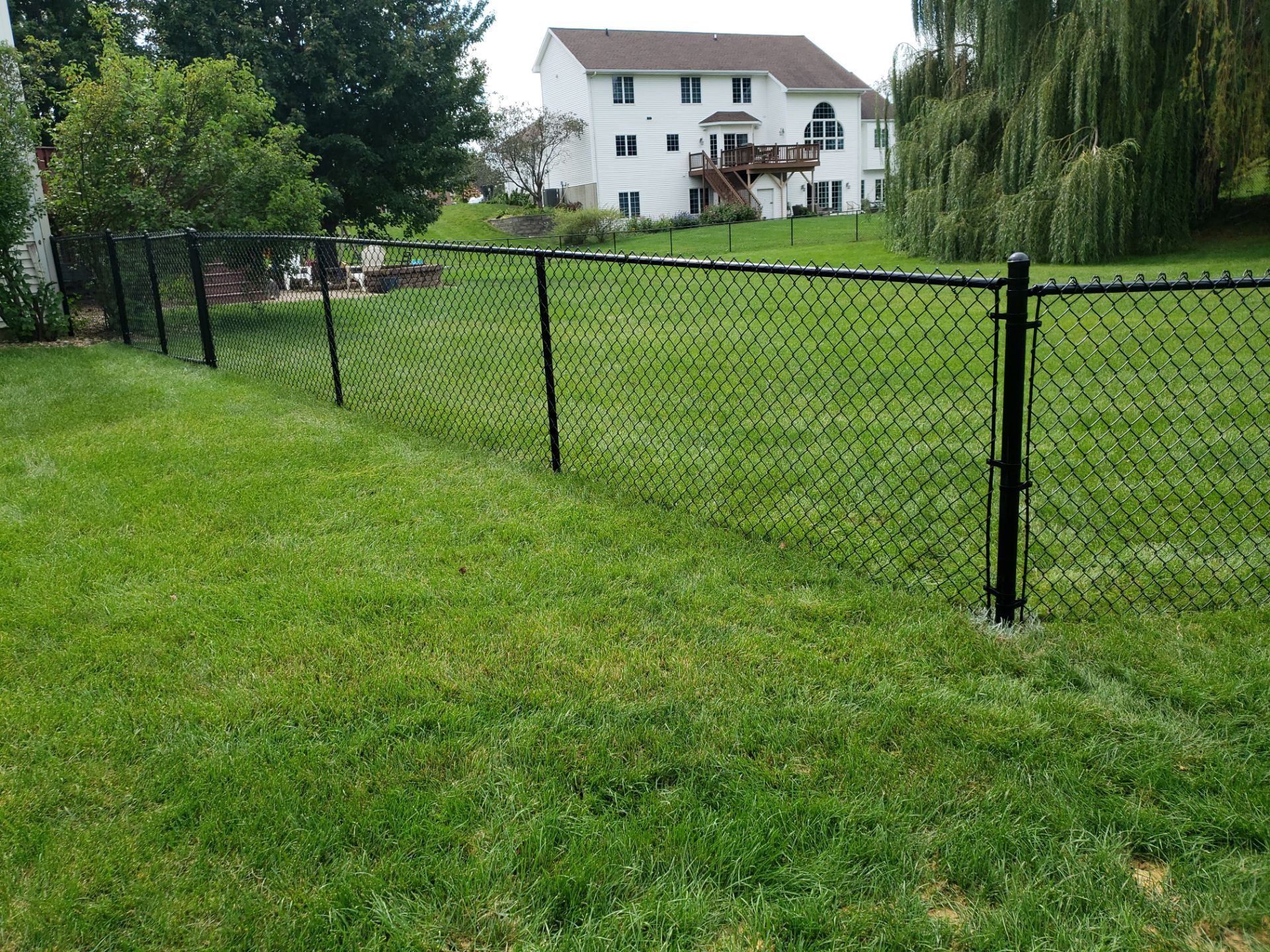 Black Vinyl-Coated Chain Link Fence Installation in Cedar Falls by Perfect Picket Fence and Stain