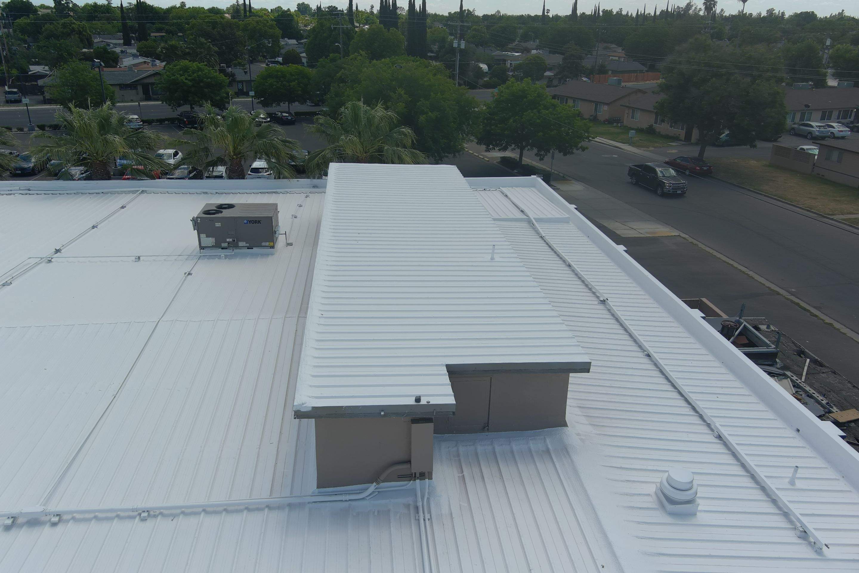 Metal roof restoration on commercial roof using Conklin Benchmark/ PUMA XL acrylic coatings over metal and foam by Straight Edge Roofing Inc