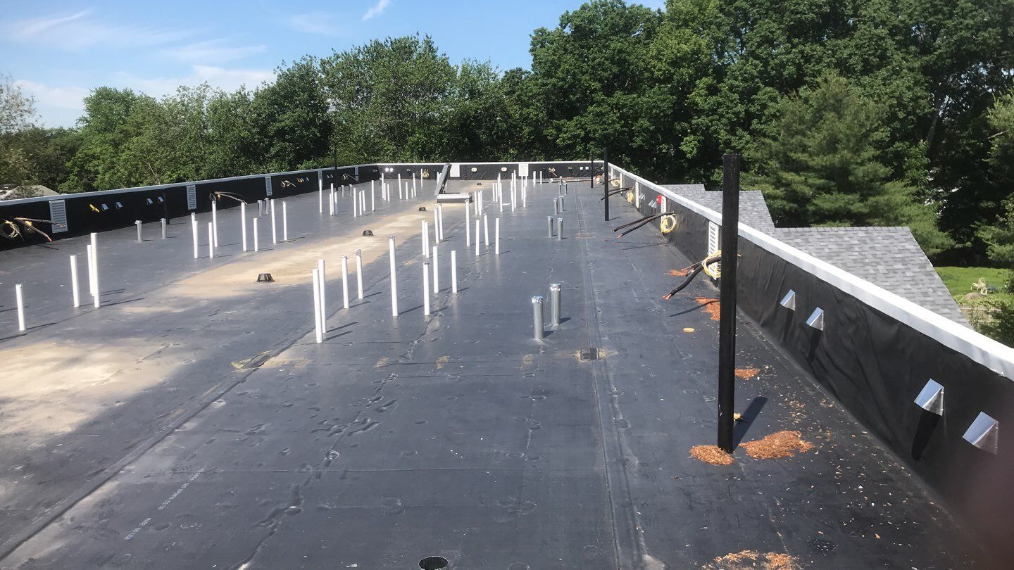Commercial Roofing Installation using EPDM with white gutters by A Plus Exterior