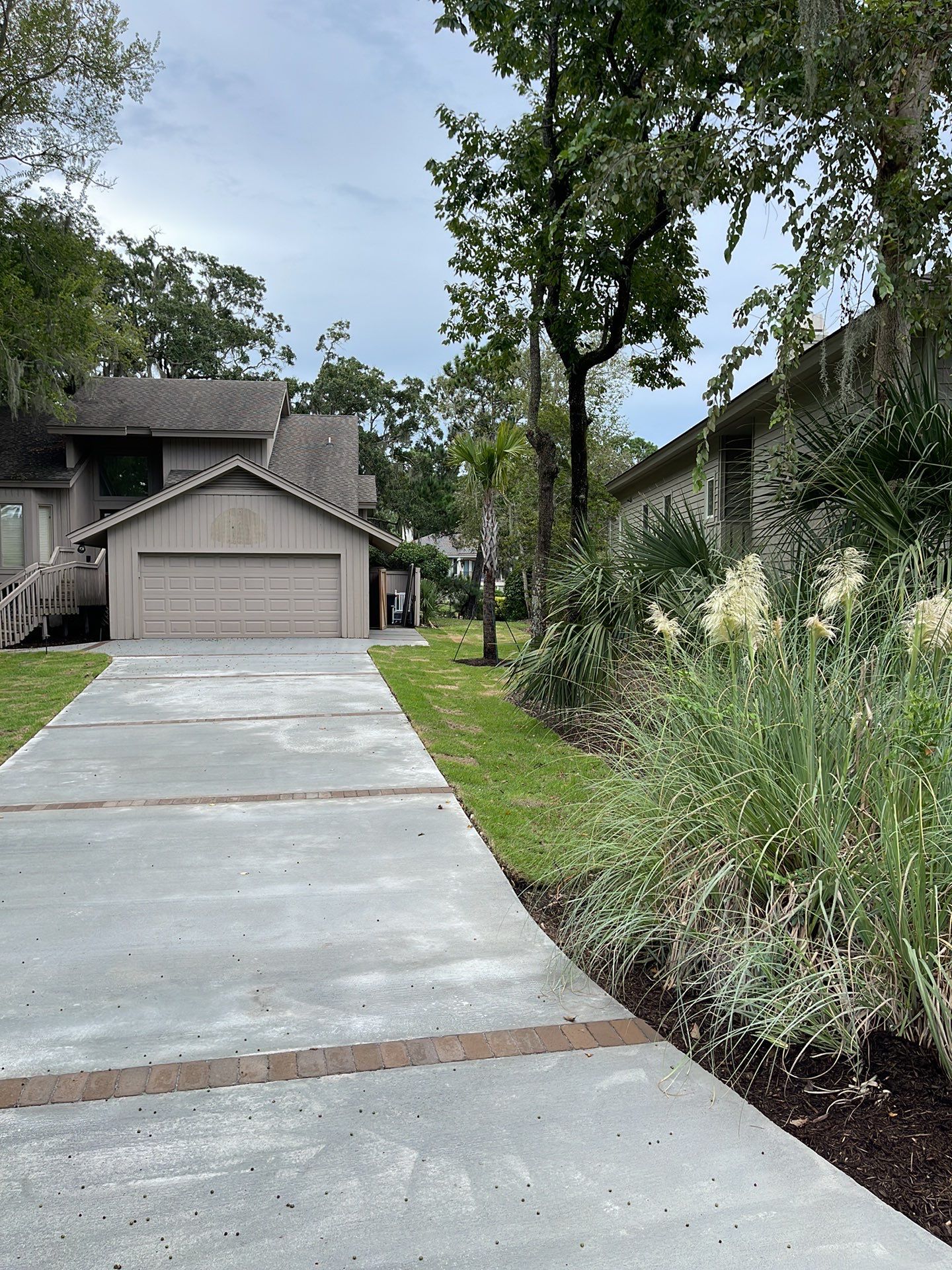 Concrete Driveway Replacement with Brick Paver Accents in Hilton Head Island by Lowcountry Scapes, LLC