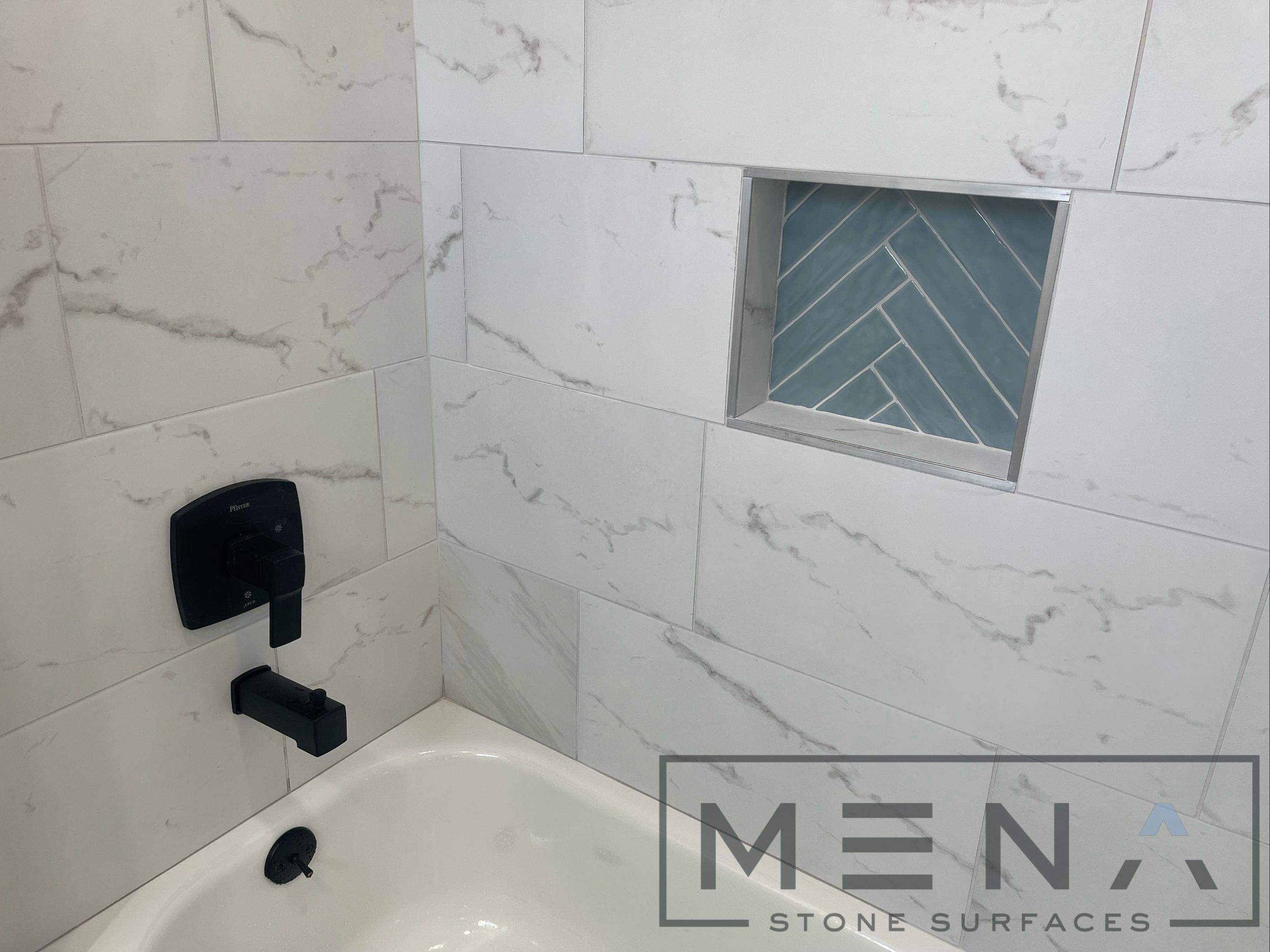 Complete Bathroom Remodel Featuring Marble Tile and Teal Herringbone Niche by Mena stone surfaces